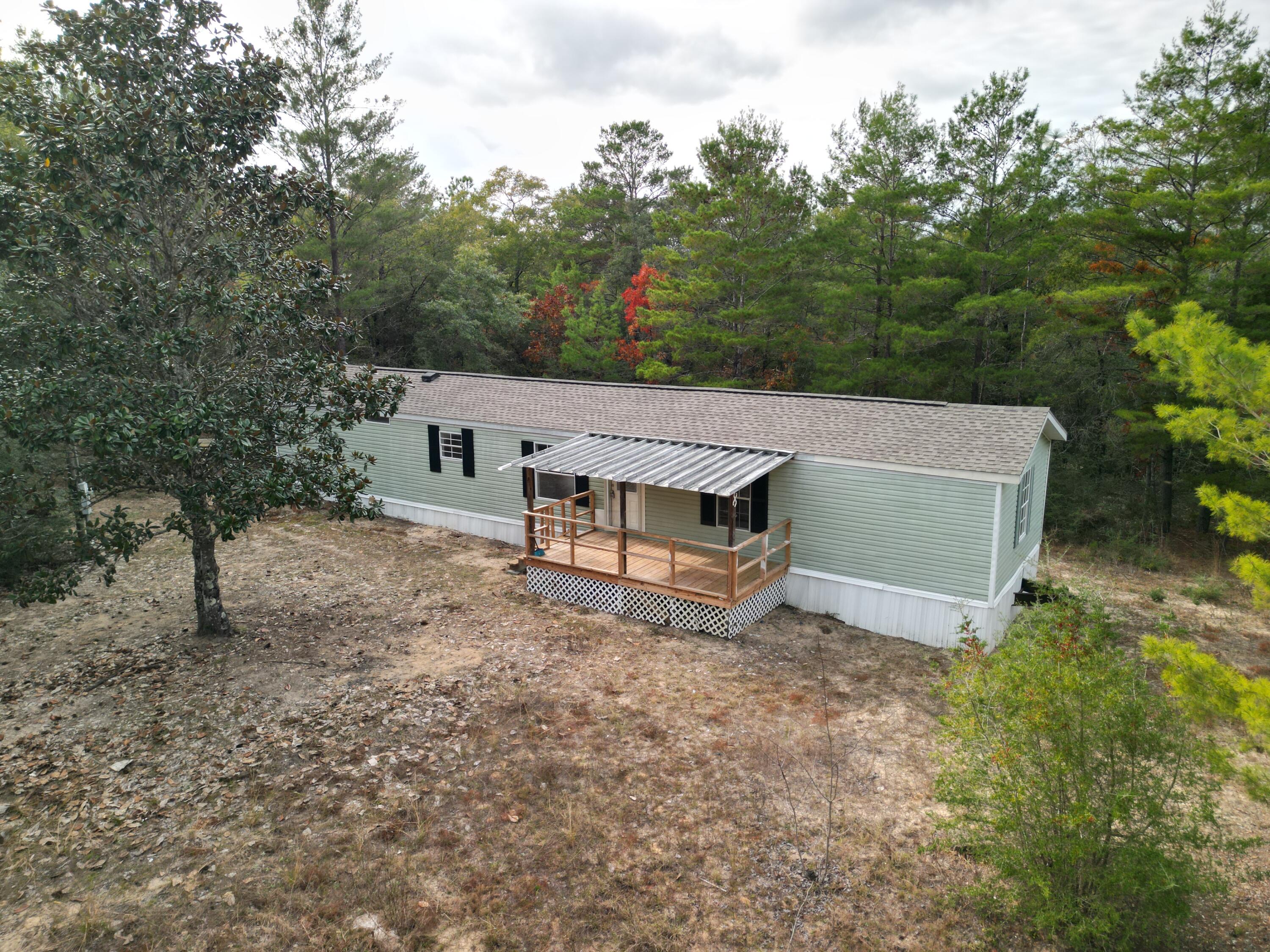 This 1997 single-wide manufactured home sits on approximately 1.6 wooded acres on the west side of White Rd. The property will be parceled from a larger parent tract, with a new parcel number and legal description provided at closing. Interior updates completed in 2025 include new flooring and fresh paint throughout. The home offers 1,056 sq ft with 3 bedrooms, 2 full baths, and a septic system. New HVAC in 2026. The acreage provides a forested setting with privacy and direct road frontage on White Rd. Aerial drone images provide a full view of the land and surroundings. Buyer to verify parcel boundaries and all final survey details.
