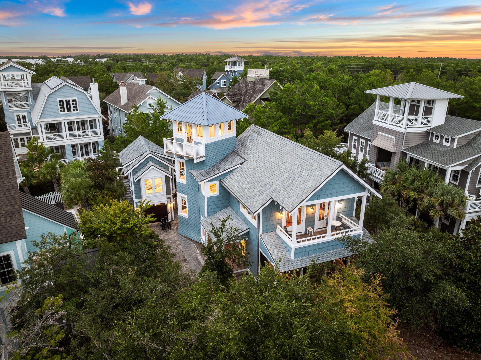 Set within the gated Bridges section of WaterSound Beach, quietly bordering Camp Creek Lake and a short walk from a private mile of Gulf shoreline, 19 Creek Bridge Way is built for the way coastal living should actually feel. Morning coffee on the porch. An afternoon on the lake. A sunset walk on the beach. Then home, the doors thrown open between the main house and the carriage house, friends in the courtyard, dinner under the porch lights.
The home is thoughtfully arranged around an elevated main living level, where the kitchen, dining, and living area opens to porches and tree canopy views, the kind of light and breeze you only get when the heart of the home sits above the ground floor. Two distinct living areas - one up and one downstairs give families room to spread out. Three bedrooms with private baths anchor the main residence. A separate carriage house above the garage adds a fourth bedroom suite with full bath and kitchenette, ideal for in-laws, teenagers, and longer stays for guests. Between the two structures, a courtyard-style dining space becomes the home's gathering spot.
The Bridges section delivers what makes WaterSound Beach singular: deeded beach access, two community pools, gathering space, security, and proximity to the WaterSound Beach Club for members, all within a low density enclave that feels removed from the busier corridors of 30A. Offered fully furnished and positioned for primary, second home, or rental use, this is one of the more compelling entry points into Bridges available today.
