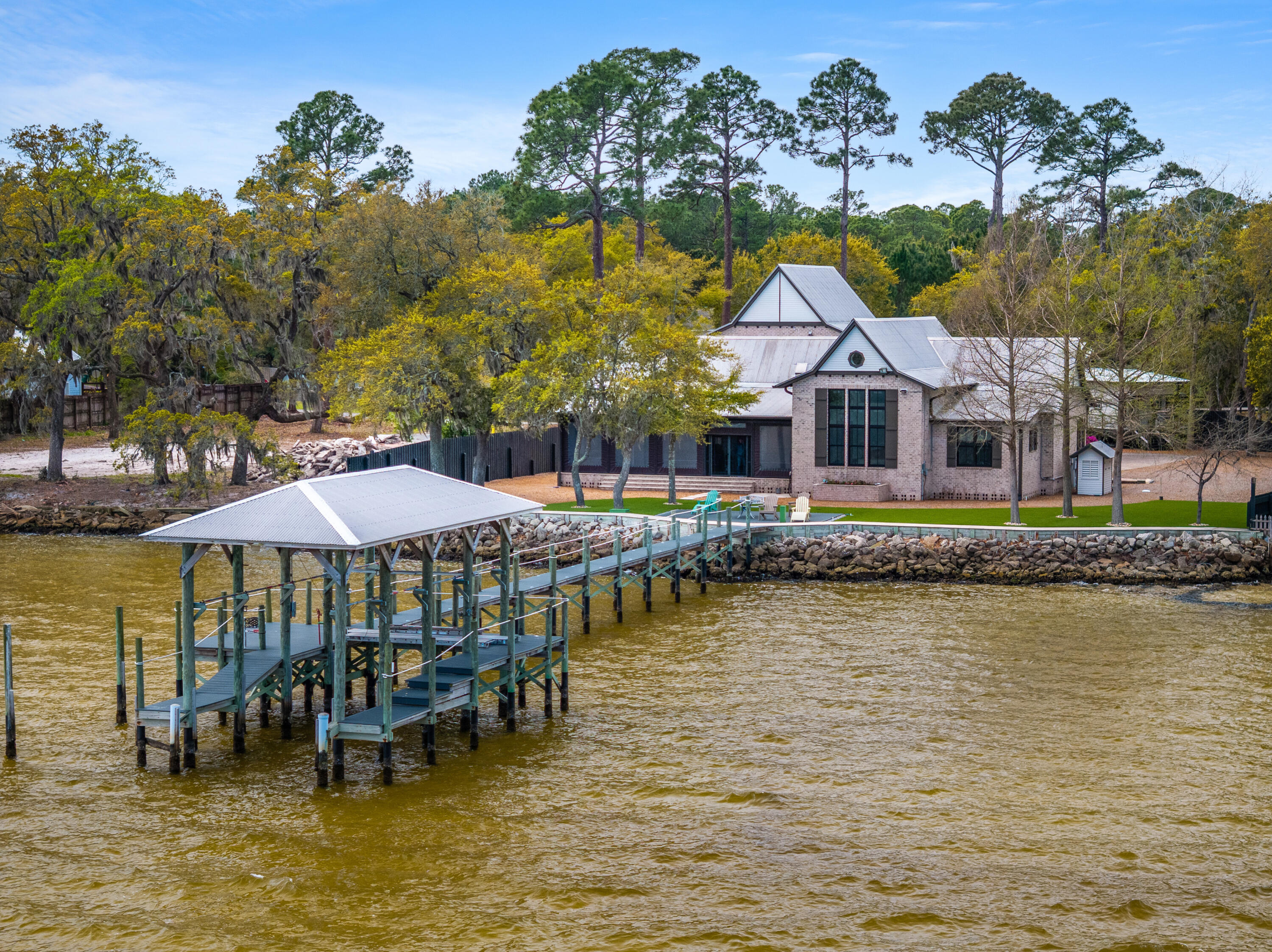 Bayfront estate on .82 acres with 140+ feet of waterfront in Santa Rosa Beach. Custom all-brick home built for durability featuring a metal roof, geothermal HVAC, private dock, and concrete seawall. Vaulted ceilings with exposed beams, expansive windows, and an open kitchen and living area capture sweeping bay views throughout. Primary suite overlooks the water with a spacious bath and private setting. Mature trees and wide-open grounds provide exceptional privacy and space to add a pool or guest house. Enjoy boating, fishing, and unforgettable sunsets from your backyard. Rare legacy waterfront opportunity with premium improvements already in place and room to create your own private coastal retreat in one of the area's most sought-after bayfront settings Positioned along the Choctawhatchee Bay, this .82-acre waterfront estate offers approximately 140+ feet of frontage--delivering a level of space, privacy, and infrastructure that is increasingly rare in Santa Rosa Beach.

This custom-built, all-brick residence was designed with long-term durability and efficiency in mind. Key structural and mechanical upgrades--including a metal roof and geothermal HVAC system--reflect the owner's commitment to quality, energy efficiency, and low long-term maintenance.

The property is already equipped for the waterfront lifestyle, featuring a private dock and concrete seawall, providing both protection and immediate access to boating, fishing, and paddleboarding.

Inside, vaulted ceilings with exposed beams define the main living space, while expansive windows frame sweeping bay views and fill the home with natural light. The open-concept kitchen and living area were intentionally designed for both everyday living and entertaining, always centered around the water.

The primary suite is positioned along the bay, offering a peaceful retreat with water views from both the bedroom and bath.

Owner-prioritized features and upgrades include:

Metal roof for durability and longevity
Geothermal HVAC system for energy efficiency
Concrete seawall providing shoreline protection
Private dock for direct water access
Solid all-brick construction
Vaulted ceilings with exposed beams
Expansive windows maximizing bay views
Open kitchen and living area designed for entertaining
Primary suite overlooking the water
Large driveway with ample guest parking
Mature trees creating natural privacy
Nearly .82-acre lot with room for pool, guest house, or expansion

Step outside and the scale of the property becomes even more apparent. The wide, usable lot offers flexibility rarely found on the bay--ideal for creating a true outdoor living environment or expanding the existing footprint.

With approximately 140+ feet of bay frontage, enjoy year-round sunsets and an unmatched waterfront lifestyle directly from your backyard.

Located just minutes from 30A, dining, and shopping, yet tucked away in a private, serene setting, this property offers both convenience and seclusion.

This is more than a home--it's a well-built, thoughtfully improved waterfront estate with the infrastructure already in place and the potential to become a true legacy property.