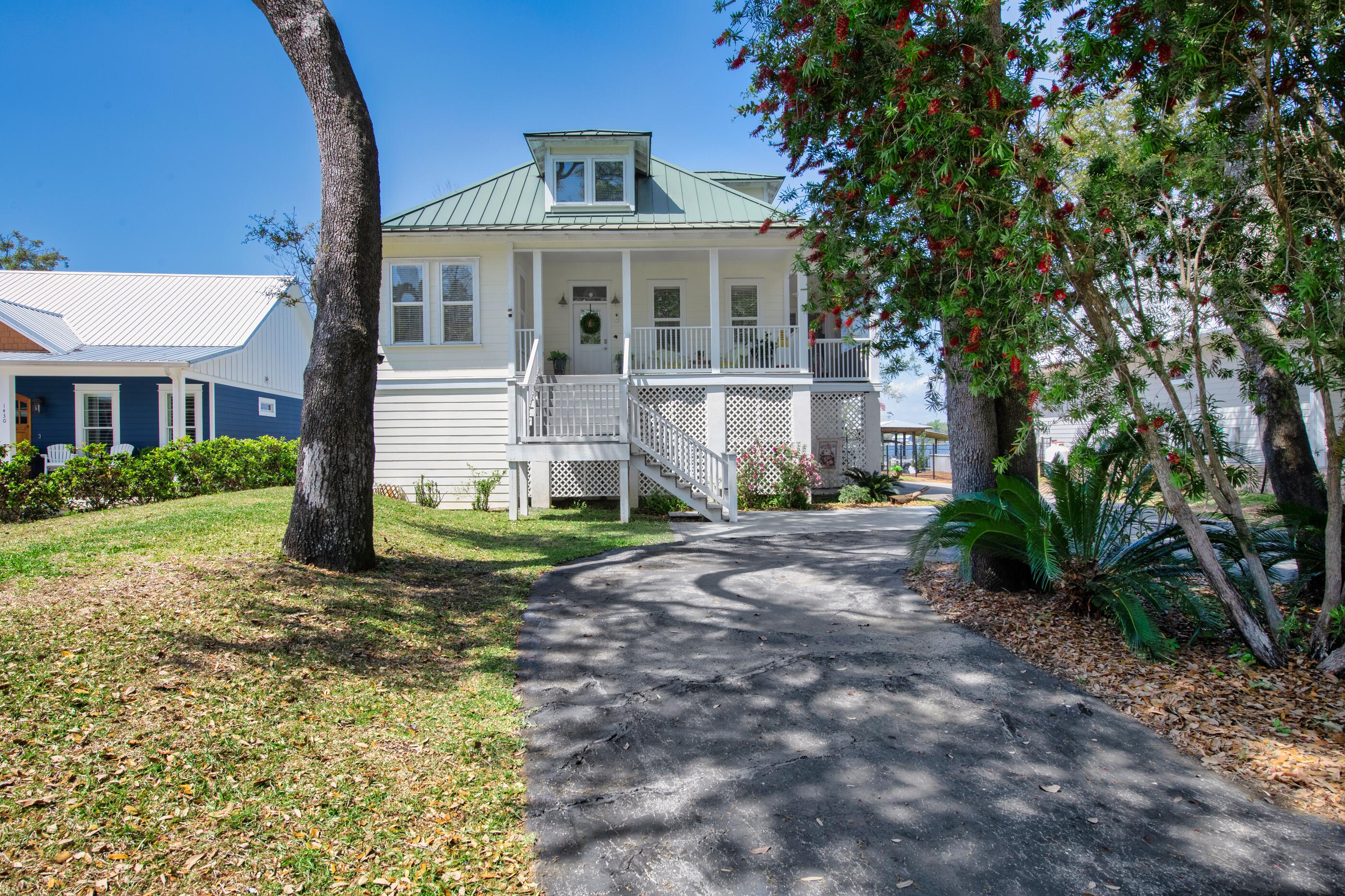 Blending relaxed elegance with unmistakable waterfront charm, this 3 BDRM 4BTH home offers the true Floridian lifestyle. Step outside to your private dock and take in the thriving coastal ecosystem, where each evening brings stunning, one-of-a-kind sunset views over the water. Step through the front door and into a bright, open interior where raised ceilings and expansive hallways create an inviting sense of space. To the right, the dining room extends into a screened-in porch, offering an ideal setting for effortless indoor-outdoor entertaining. To the left, a versatile drawing room or bonus space is complemented by a nearby full Guest Bath and laundry room. Continuing down the hall, you're led into a expertly curated kitchen featuring stainless steel appliances highlighted by an immaculate Verona stove imported from Italy, a beautifully designed hood, and ample countertop space for both everyday living and entertaining. The living room seamlessly connects the dining area and primary bedroom, while double doors open to a screened-in back porch-creating a natural flow for indoor-outdoor living. The Primary Bd offers access to the back porch and features a spacious walk-in closet. The Primary bath showcases artistic tile work, a double vanity, and a walk-in shower-blending modern design with a unique touch. The lower level offers a convenient half bath, additional refrigeration, a spacious living area, and a dedicated storage room. It also connects to a garage with room for more than two vehicles and provides access to the ground level screened-in back porch-ideal for extended living and entertaining. Upstairs from the main entry, you'll find two guest bedrooms with a full bath situated between them, offering comfort and privacy for family or visitors. Whether you're seeking a full time residence or a private coastal retreat, this home offers an exceptional opportunity to experience the Florida lifestyle at its finest. 

The boat lift was used for a 20', 4700 lb boat.  

The home is built on concrete rebar pilings.  

Buyer(s) are responsible to personally verify all details for property and dimensions. Any information contained in this listing is believed to be accurate but is not guaranteed.