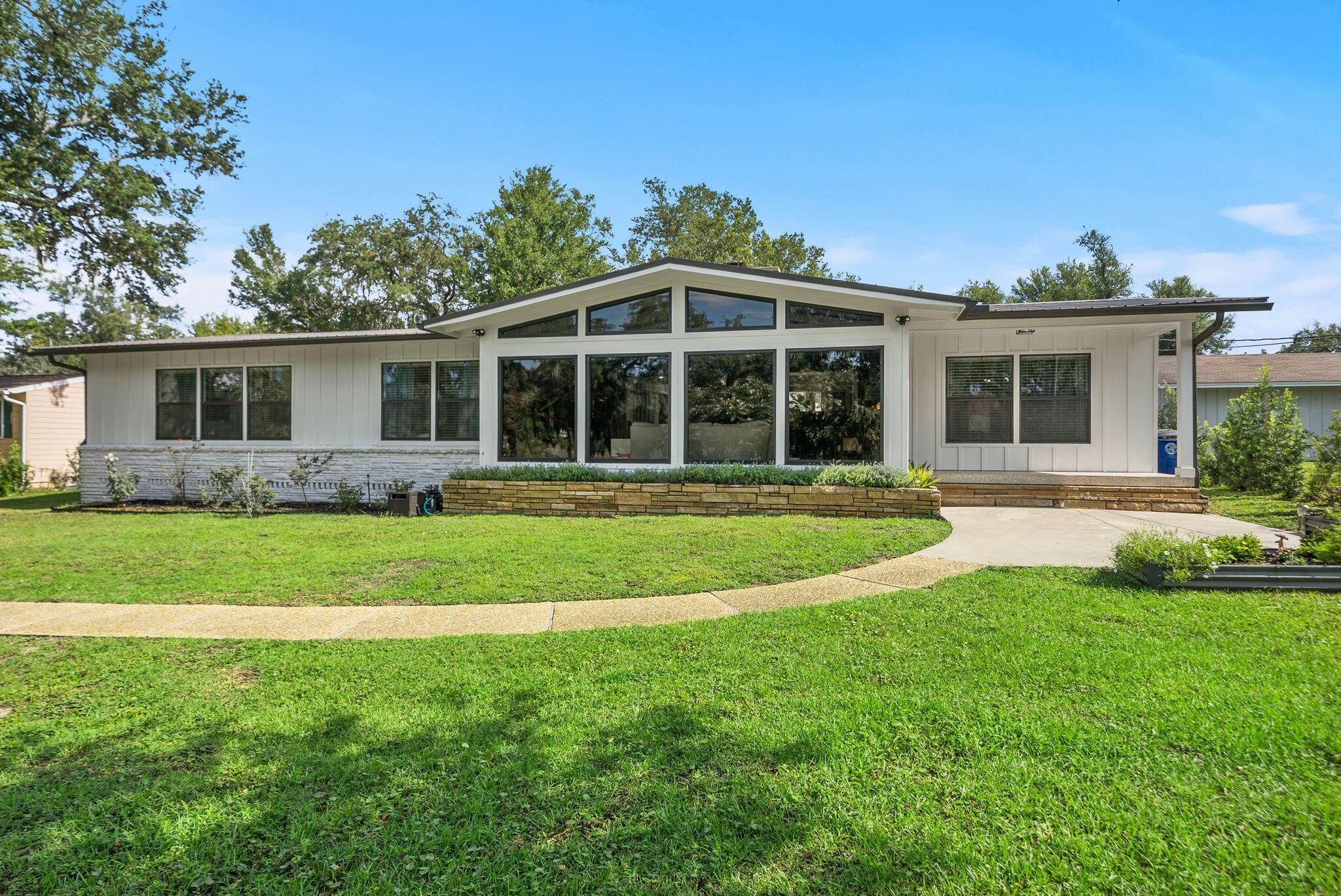 *OPEN HOUSE WEDNESDAY, JULY 15 from 3-5PM* Sitting high on a hill, beneath hundred year old oak trees and on an over 1/3-acre homesite with NO HOA, this 3-bedroom, 2-bath mid-century modern beauty sits directly across from the water in one of Panama City's most historic neighborhoods...The Cove. 

And this isn't a ''close to downtown'' home where you still need to get in the car to go everywhere. This is walk-to, bike-to, golf-cart-to booming Downtown Panama City. Cruise the oak-canopied streets to Trigo San Francisco Style Deli for lunch, grab a coffee (or crepe, or glass of wine!) at The Press, or park the golf cart at History Class for a cold local pour. Waterfront dinner at the St. Andrews Bay Yacht Club? Ten minutes by cart if you're a Member. Downtown's growing lineup of shops, live music, and the regular scheduled community activities like the Saturday Farmer's Market's make living in the Cove even better. 

Step inside, and you're greeted with 2,298 square feet of single-level living with original mid-century modern character. Original terrazzo and heart pine floors run throughout and this is the kind of detail you can't recreate, only preserve. 

The living room is anchored by vaulted, beamed ceilings, gas fireplace, and clerestory impact windows that make you stop in your tracks with the natural light and beauty they bring to this home! The living room flows into the dining room that connects to the kitchen for easy everyday living and easier entertaining. There is a charming light-filled, breakfast room off the kitchen that offers backyard views and the gas fireplace, as well. A large laundry room, home office and storage room are also located off the breakfast room and near the entry to the attached 2-car garage. The 2-car garage is a RARE find in the Cove and with alley access and additional parking, you're going to love the storage and parking for all your friends, family and their golf carts and cars! 

The kitchen was fully reimagined in 2022 with a new, functional layout, gas cooktop, wall oven, microwave, refrigerator, custom cabinetry, electrical, plumbing and marble countertops. The roof was installed in 2020, the exterior was completely renovated in 2024 with hardie board siding and the HVAC system was installed in 2025. 

The primary suite is a true retreat with a large bath, separate shower and toilet area and a large walk-in closet. The other two oversized bedrooms give real breathing room, including larger than typical closets in the Cove. A guest bath is easily accessible from the hallway for both guests and two guest bedrooms and is a fun nod to the mid-century modern design! 

This home offers NO HOA and is just a rare mid-century gem, perched up high on a hill, in a charming neighborhood where the water's across the street and downtown's a golf cart ride away. 

If you're ready to start really living in the Cove, this mid century modern beauty is move-in ready for you to call home!