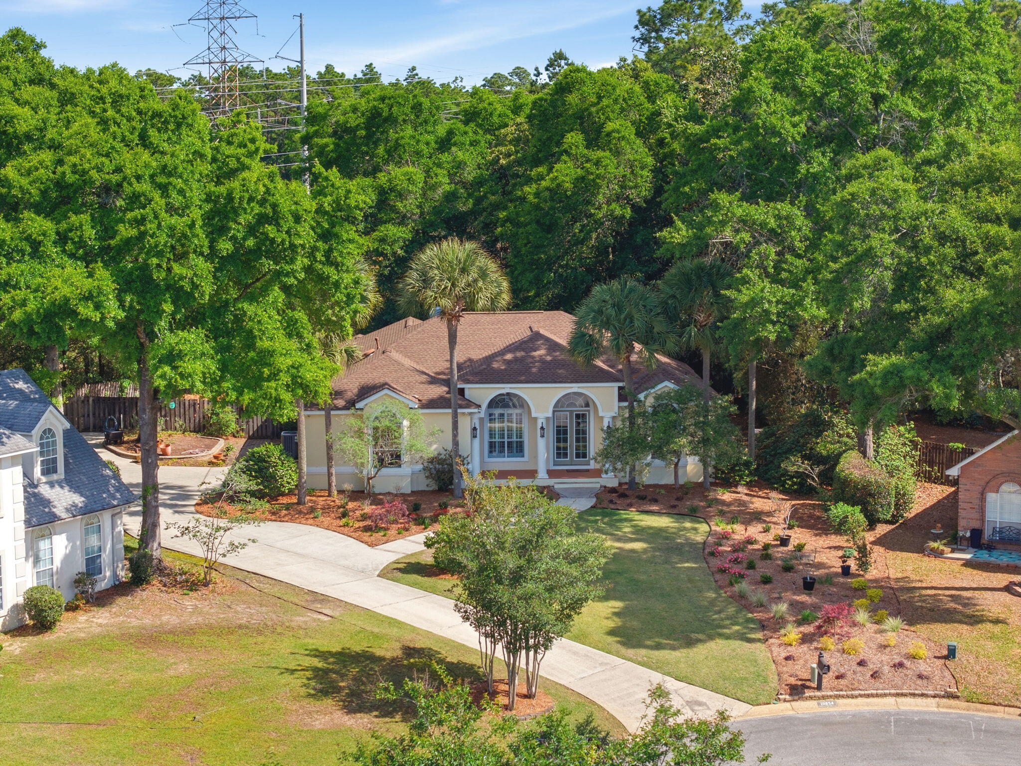 This is the one you've been waiting for! An exceptional executive home that perfectly blends luxury, privacy, and peace of mind. Welcome to this stunning residence in the highly sought-after upscale neighborhood of Scenic Hills North. This home truly stands out and will not last long. Built by Randy Lemon, this beautifully crafted South Florida-style home showcases exceptional quality and elegant architectural details, along with a thoughtfully designed open floor plan featuring soaring 10-11+ ft ceilings, 8 ft doors, archways, 18'' diamond-set tile, and a wood-burning fireplace with custom mantel and built-ins. The split-bedroom layout offers both privacy and functionality, with spacious secondary bedrooms and a well-appointed shared bath. The primary suite is a true retreat, featuring two large closets and a luxurious, updated bath complete with a reconfigured walk-in shower, garden tub, double vanity, heater, and designer tile finishes. The kitchen is a showstopper! Perfect for entertaining with updated appliances, a large breakfast bar, and seamless flow into the great room. Natural light fills the home through glass sliding doors, drawing your eye to the peaceful, private backyard that backs up to the University of West Florida nature preserve offering no rear neighbors and serene views year-round. Enjoy true indoor-outdoor living with a screened-in porch, ideal for relaxing or entertaining guests. Major upgrades provide peace of mind, including the roof, HVAC, tankless water heater, whole-house generator, and more. Perfectly situated high and dry on a quiet cul-de-sac with a side-entry garage and excellent curb appeal, this home checks every box. Homes like this rarely come available. Schedule your showing today before it's gone.