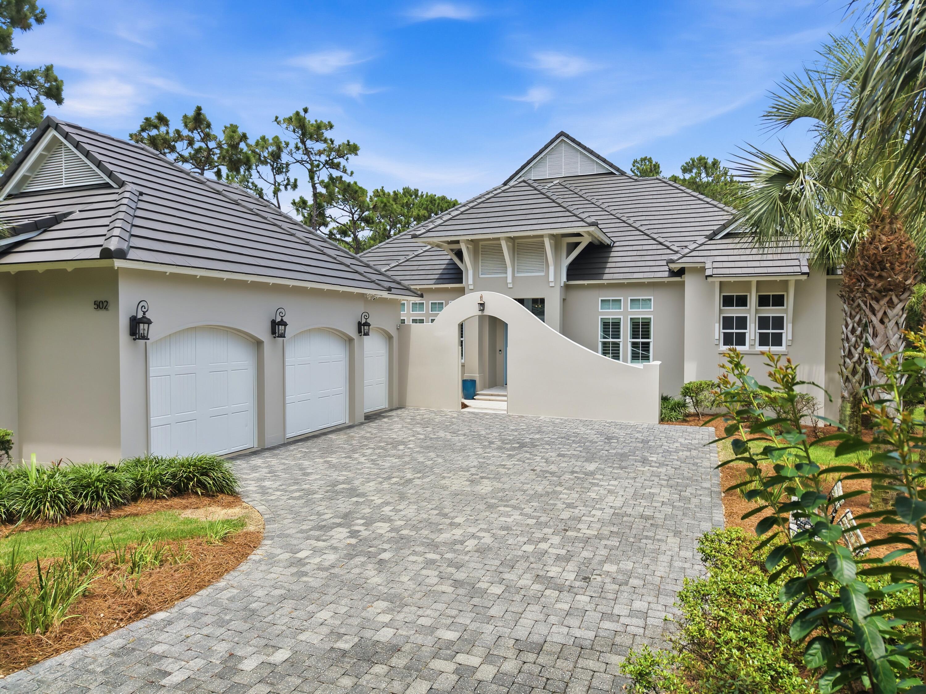 Custom-built pool home in the prestigious, gated Regatta Bay golf community offers the perfect blend of refined elegance and effortless coastal living. A dramatic 12-foot coffered foyer with reclaimed solid wood accents greets you, complemented by custom 8-foot mahogany entry doors. The spacious living area, anchored by a fireplace, flows seamlessly into the chef's kitchen under an impressive open floor plan featuring soaring ceilings, rich hardwood floors, and abundant natural light. Floor-to-ceiling sliders in the living area frame breathtaking views of the outdoor entertainment area, complete with a summer kitchen, heated pool, and hot tub -- creating a warm yet sophisticated atmosphere perfect for relaxed living and elegant indoor-outdoor entertaining. The chef's kitchen is a showstopper, featuring luxurious quartz countertops, a massive quartz island, a 48-inch Thermador gas range, Sub-Zero refrigerator, polished nickel hardware, a walk-in pantry, and a wet bar with icemaker. The first-floor primary suite is a true retreat, complete with a sitting area offering serene pool views, dual walk-in closets, and a spa-like bath with double vanities, a deep soaking tub, and a separate tiled walk-in shower. Also on the main level are a guest suite with en-suite bath and walk-in closet, a flexible third bedroom/office, and an oversized laundry room. Upstairs, a second living area with an additional bonus room provides versatile living space,   with two additional guest bedrooms each feature generous walk-in closets and two full baths. A covered balcony overlooking the pool and golf course offers another peaceful vantage point, and spacious attic storage. This energy-efficient home includes a solar power system, whole-house generator, impact-resistant windows and doors, insulated wind-rated garage doors, spray foam roof insulation, superior sound-dampening insulation, custom solid wood cabinetry and shelving, and Schluter waterproofing systems throughout. Built for year-round living and entertaining, this residence delivers luxury and peace of mind in one of Destin's most sought-after communities
