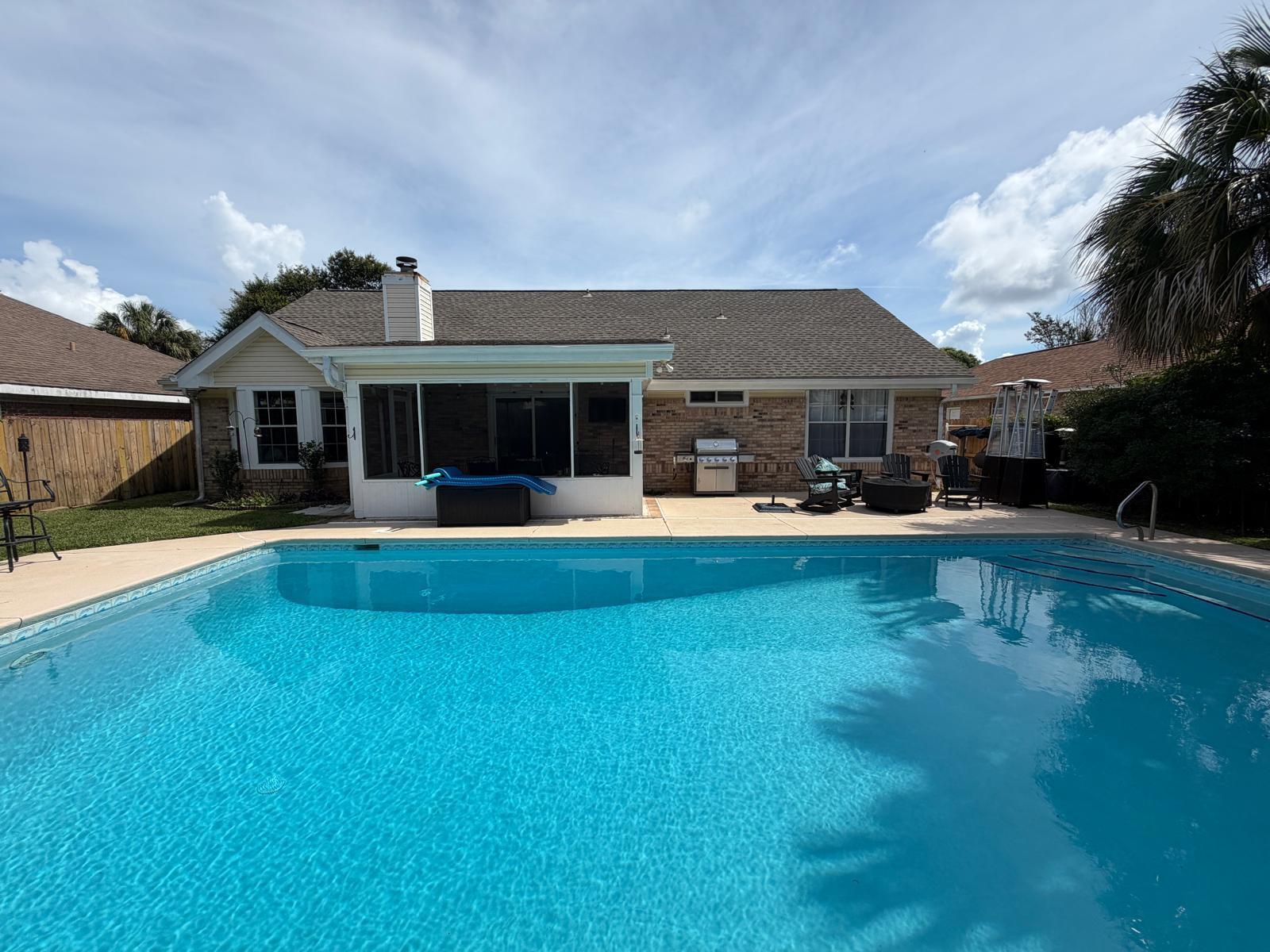 Welcome to your dream home in the heart of Destin, where comfort, style, and coastal living come together in one exceptional property. This beautifully maintained four-bedroom, three-bathroom residence offers an ideal blend of spacious living areas, thoughtful updates, and outstanding outdoor amenities.

Step inside to discover rich hardwood flooring that flows throughout the main living and dining spaces, creating warmth and timeless elegance. The inviting living room features soaring vaulted ceilings and a cozy fireplace, providing the perfect setting for relaxing evenings or entertaining guests. Just beyond the living area, a screened-in back porch offers a bright and tranquil retreat, ideal for morning coffee, reading, or enjoying views of the backyard.

The thoughtfully designed floor plan includes a spacious first-floor primary suite complete with an en suite bathroom and two generous walk-in closets. An additional guest bedroom and a beautifully renovated full bathroom are also conveniently located on the main level, providing flexibility for family or visitors.

The well-appointed kitchen is sure to impress with granite countertops, stainless steel appliances, and a charming breakfast area perfect for casual dining. There is also a formal dining area between the kitchen and living room. Moreover, a versatile flex room on the first floor offers endless possibilities and can easily serve as a home office, fitness room, playroom, or media space. Upstairs, you'll find two additional bedrooms, a shared full bathroom, and a cozy loft area that provides the perfect space for a reading nook, study area, or additional lounge space.

Step outside to your private backyard oasis featuring a large in-ground swimming pool (just re-plastered) and a fully fenced yard with small shed, creating the ultimate setting for outdoor entertaining, family gatherings, or simply enjoying Florida's year-round sunshine. The property also includes a two-car garage and ample driveway parking for multiple vehicles.

Ideally located in one of Destin's most desirable areas, this home offers convenient access to premier shopping, dining, entertainment, the Destin Harbor, world-class fishing, and the Emerald Coast's renowned sugar-white beaches and emerald-green waters.

Whether you're looking for a primary residence, a second home, or an investment opportunity (long-term rentals only), this exceptional property offers the perfect combination of location, space, and lifestyle that makes Destin one of Florida's most sought-after coastal communities.

Schedule your private showing today and experience all that this remarkable home has to offer.