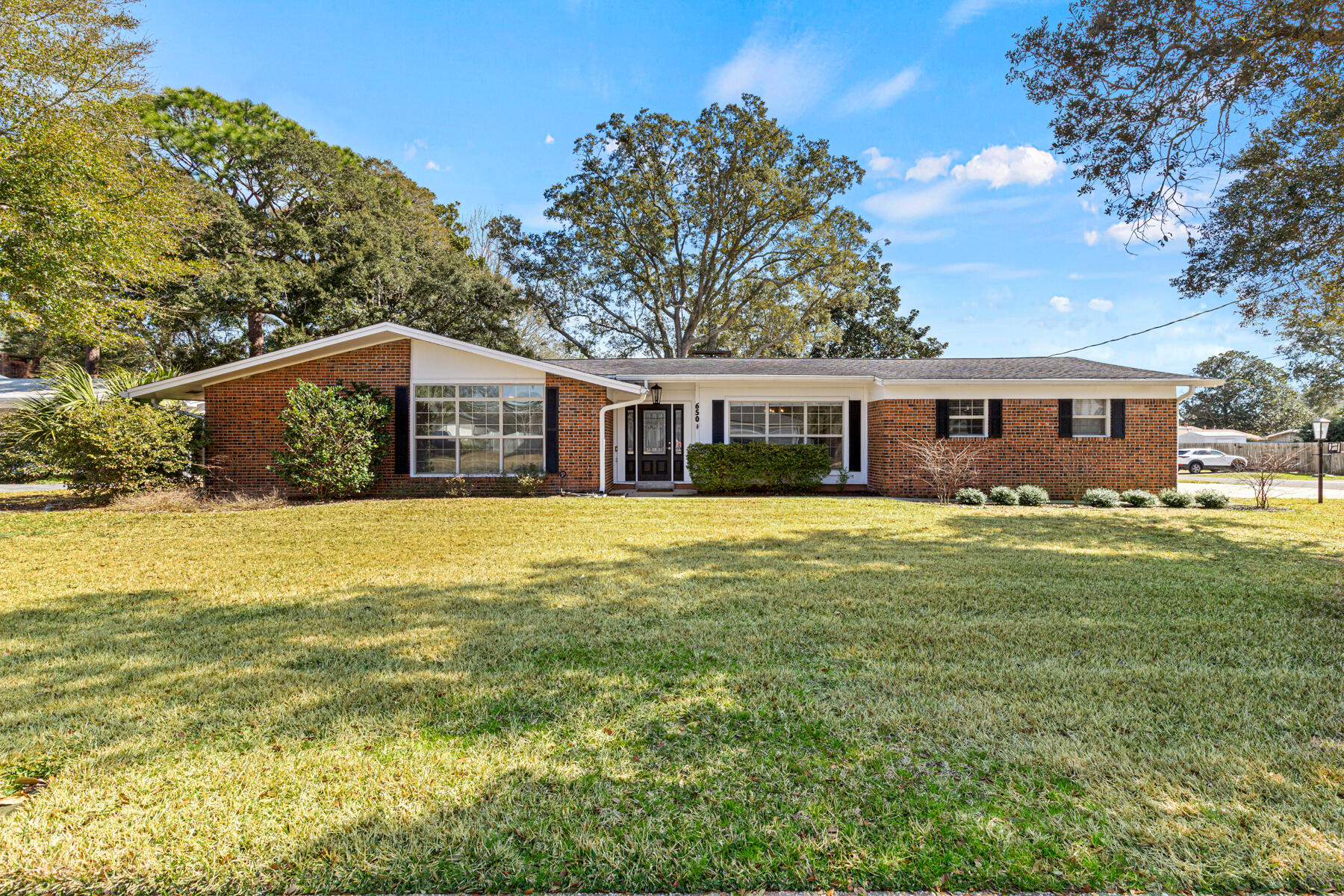ONE TO SEE! STYLISH WELL MAINTAINED, FRESHLY PAINTED, ALL BRICK HOME ON LARGE CORNER LOT! 
THE FIRST CURB APPEAL IMPRESSION IS OLD CHARM MIXED WITH MODERN STYLE. THE ANGULAR ROOF LINE & TALL WINDOWS SETS THIS ONE APART! Upon entry the FOYER greets you to a beautiful door w/deco design privacy glass & a roomy welcoming space of travertine tile and a spacious coat closet. To the left is a large office/den space w/tall angular deco trimmed ceiling, dramatic window wall, fan and wood plank laminate floor. On the other side is the DINING ROOM that boasts simple elegance. A chandelier, chair molding, deco ceiling and impressive windows completes this room. The cozy LIVING ROOM impresses w/wood burning brick and tile faced fireplace, two sliders w/roll blinds that access the screened patio, deco ceiling & fan. The galley type KITCHEN overlooks the Living room and wows with an angled brick accent wall, window sink, gorgeous granite, newer SS appliances, back splash, diamond laid travertine flooring, Deco ceiling and a deep wood shelved pantry. THE MASTER BEDROOM is spacious with slider to back patio, fan & his/her closets. The MASTER BATH has travertine tile shower w/glass door, travertine tile floors & newer vanity. 
ADDITIONAL NOTABLE HOME FEATURES:
2021 TRANE AC Unit. Tankless Electric Water Heater (mounted inside). Large Corner Lot. NEWER Horizontal Designer Fence w/2 Entry Gates, Side Entry Double Gate to a Boat/Camper Pad. 
16 x 10 Yard Shed with Windows. New Garage Door Opener. Large 21 x 13.5 Screened Porch w/Two Fans, Half Wall perimeter w/Lg Dog Door and Additional Covered 5 x 13.5 Open Air Grilling Patio. Whole House Updated Wiring & Panel w/Surge Protection. Irrigation System. NEW Interior Paint (Whole House). Main Rooms & Hallways have Coastal Deco Ceiling & Baseboard Trims. Roomy Laundry Room w/Cabinetry & Exterior Door Access. Large Bedrooms w/Newer Carpet, Fans, Blinds. BR 4 is 15.5 x 12. 
BATH 2 Has Tall Double Sink Vanity, Travertine Tiled Tub/Shower Combo Nestled in Nook. Hallway - 2 Linen Closets w/Wood Shelving. Large Garage 20 x 23. Gorgeous Oak Tree in Rear Yard. Fantastic Location Near AF Bases, FWB Golf Course (with newly refurbished greens), Beaches, Shopping, Restaurants, Schools (To Include Kenwood Elementary) and more. 
Make This A Must See!