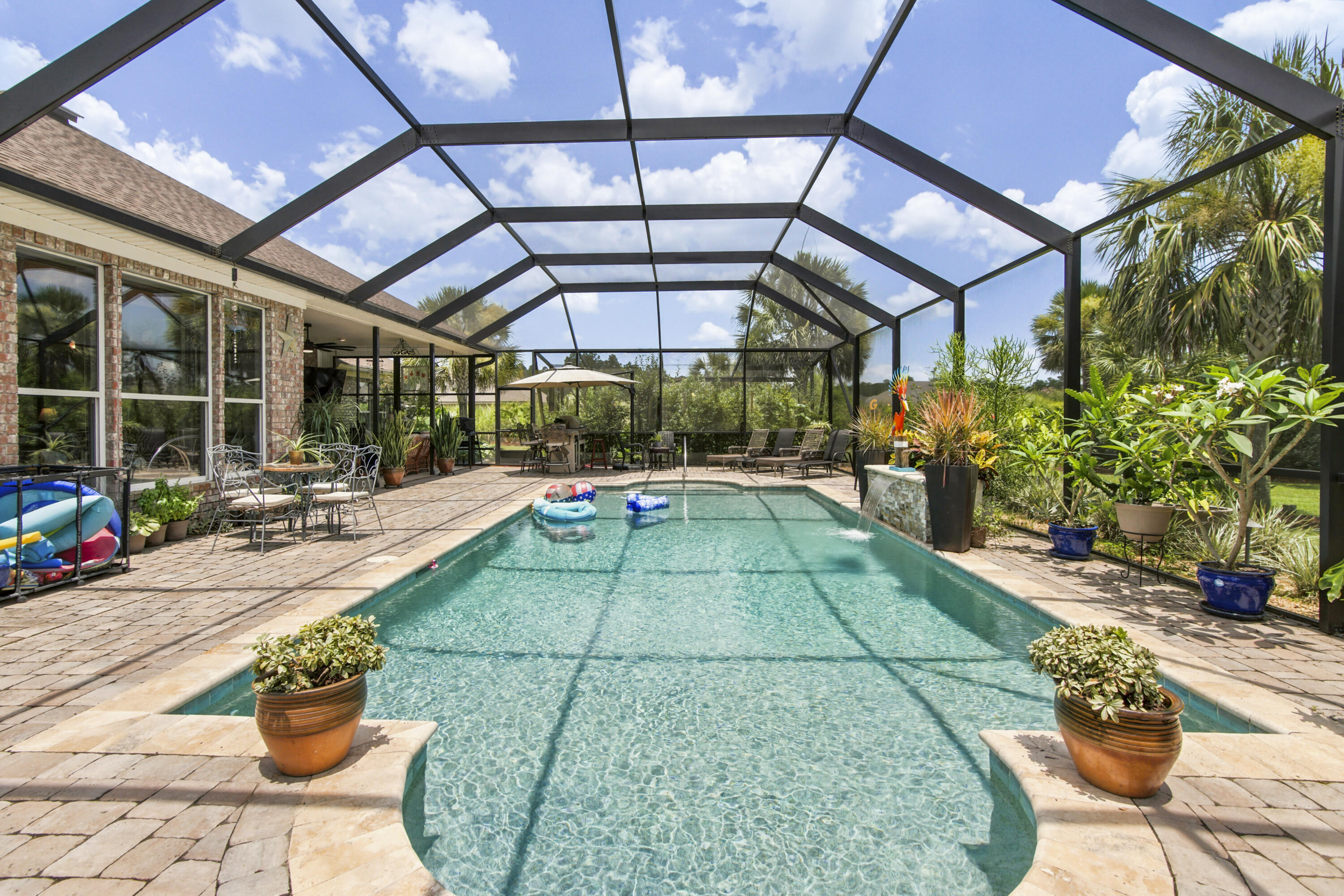 Luxury Golf Course Living on a Rare Double Lot w POOL/HOT TUB  in Windswept Estates
Welcome to 69 Fairway Crossing, a stunning custom home built by Marlin Design & Construction, ideally situated on a double lot (.67 acres x 2!)within the prestigious golf community of Windswept Estates in Freeport. Combining timeless craftsmanship with resort-style amenities, this exceptional residence offers luxury, privacy, and space both inside and out.
Featuring over 3,000 square feet of thoughtfully designed living space, this beautiful home offers 4 bedrooms, 3 bathrooms, soaring ceilings, custom architectural details, and spacious gathering areas perfect for entertaining and everyday living. The chef-inspired kitchen boasts granite countertops, abundant cabinetry, and the convenience of a double pantry, providing exceptional storage and functionality. Added bonus is a  6' tall custom spice rack, under cabinet lighting, 5 Burner Gas Cooktop and Farmers Sink w Hot Water Dispenser. 
The luxurious primary suite serves as a private retreat, complete with a spa-inspired primary bath featuring a Jacuzzi soaking tub, separate walk-in shower, double vanities and generous closet space.  
Front room  has stained-glass doors and back office has Oak Barn Doors.  Tankless Water Heater included and  North & South accesses to EXTRA attic storage w pull-down stairs. Windows have UV Reducing Solar Film to keep you cool all summer! The drive way has been expanded and Garage is extra deep.  SO MANY EXTRAS! Step outside to discover your own private oasis. The expansive screened-in pool enclosure offers year-round enjoyment and creates the perfect setting for relaxation and entertaining.. The fully equipped outdoor kitchen makes hosting family and friends effortless, (hookup for propane grill ready to be enjoyed),landscaped grounds are enhanced by 7 mature palm trees throughout the backyard, creating a true Florida resort atmosphere. Bushes and perennial flowers throughout give the feeling of being in the country. Landscape Lighting lights up your  evenings in this  private oasis. A deep-well irrigation system helps maintain the lush landscaping efficiently and economically. The rare double lot provides unparalleled privacy, additional outdoor living space, and endless possibilities. There's a fire pit w Granite benches, Security Lighting front and south sides of house. 
Located in the highly sought-after community of Windswept Estates, residents enjoy access to championship golf, community amenities, scenic walking trails, and the convenience of being just minutes from the sugar-white beaches of South Walton.
Custom built, thoughtfully designed, and beautifully appointed, 69 Fairway Crossing offers more than a home. It offers a lifestyle.