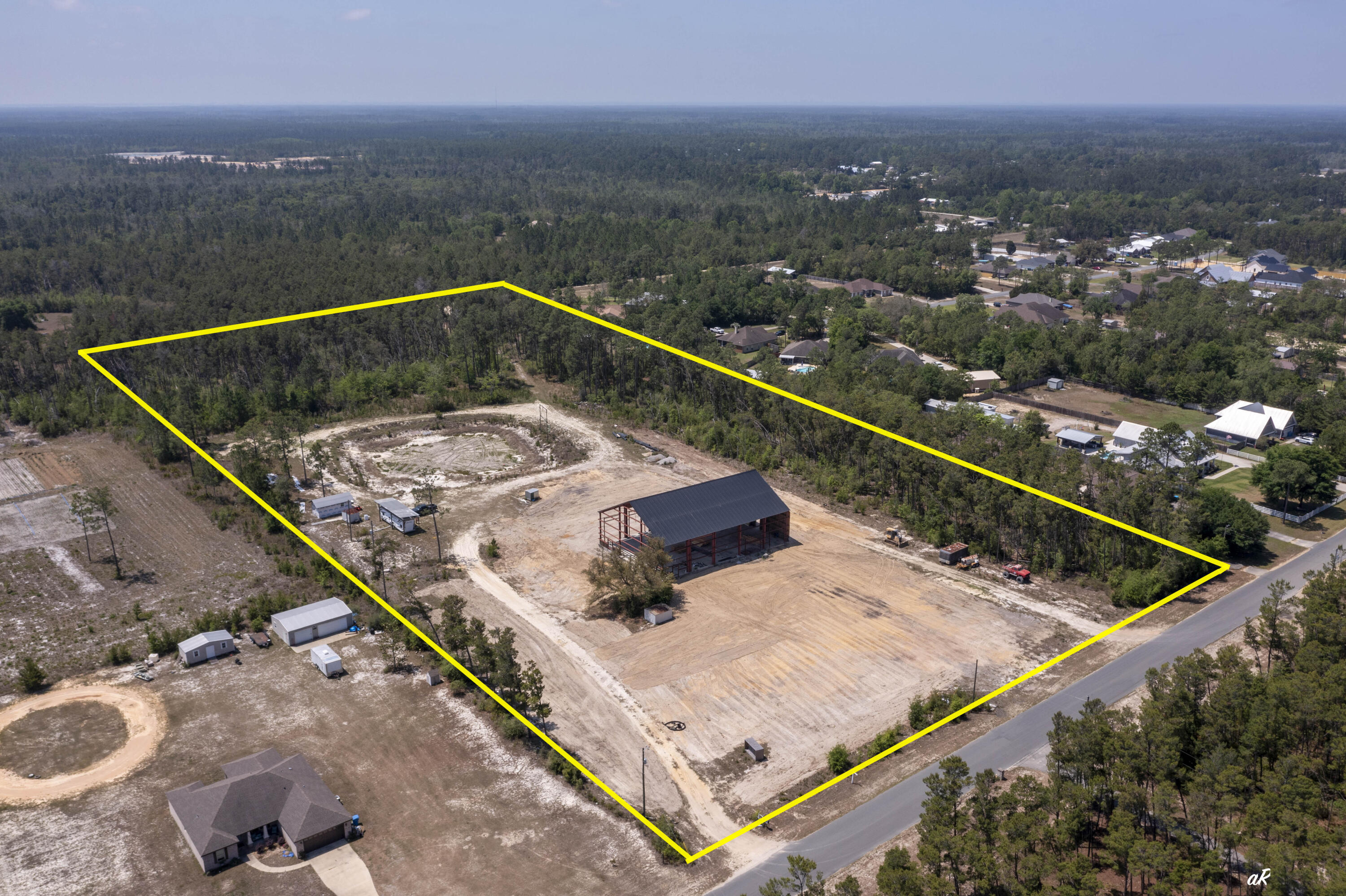 Highly Motivated Seller! 11 ACRES! Bonus!  Seller will remove the existing red iron building and offer a $50,000 price reduction, creating added flexibility and opportunity for future use of the property. Rare opportunity in booming Southport! This 11-acre property offers the space, privacy, and flexibility that is almost impossible to find today. Located on a paved road with no HOA, this property gives you the quiet lifestyle people want while still being close to everything--about 10 minutes to Lynn Haven, 20 minutes to the airport, and 30 minutes to the beaches and Pier Park. With new construction and growth expanding north, this is a prime opportunity for a private estate, family compound, or potential subdivision for multiple homes or spec builds. The property already has septic, well, power, and full camper hookups on site. There is plenty of room for your RV, boat, heavy equipment, and all the toys, plus space to create your own micro-farm with chickens, horses, goats, and more. A massive red iron building has also been started, offering approximately 14,000 square feet of heated and cooled space when completed. Permits are pulled, and a floor plan is available. Whether you are looking for land, privacy, investment potential, or room to build something big, this Southport property is an opportunity worth paying attention to, come tour today!