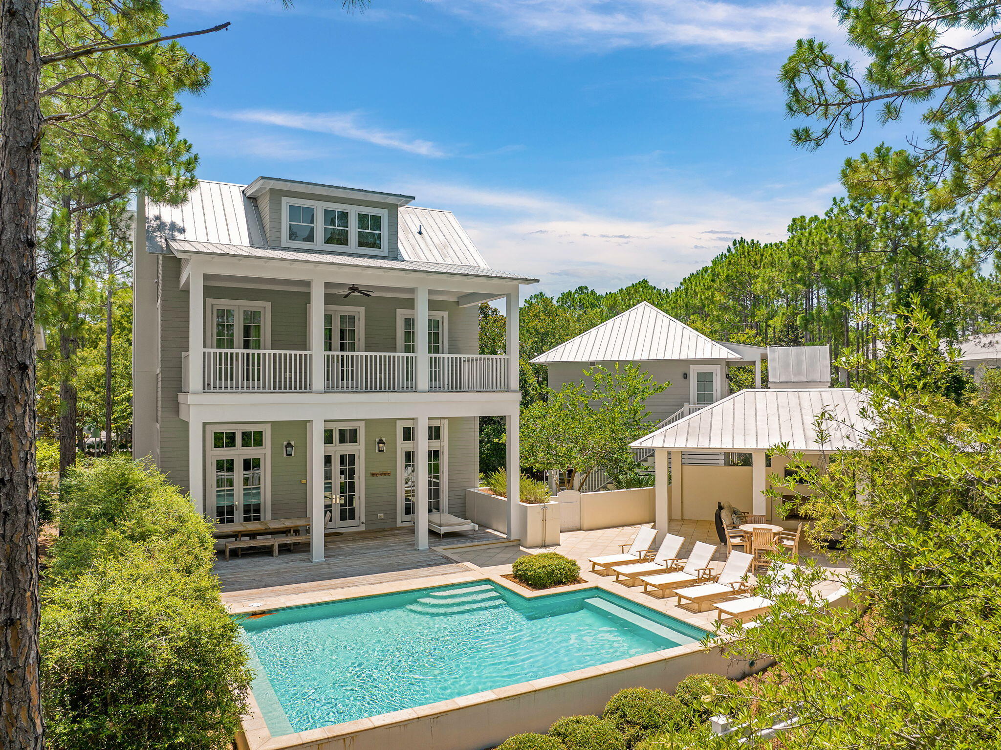Located in Phase 2, this one family owned, never before rented home offers the privacy of a backyard preserve, a front yard facing a park area, while also being tucked nicely inside a private cove.  This home has one of the largest private family pools inside the Watercolor community and was designed by the Stackable Group and built by Cole construction.  A Peacock paver pool deck with fully fenced in back yard  expands into a summer kitchen with an outdoor fireplace.  The carriage house is fully equipped with a kitchen, full bath and extends over a full capacity two car garage.  Inside the home you will find grey washed floors, mosaic marble bathrooms, and souring ceilings. A large fireplace anchors the living and dining area. This home offers large rental projections while also providing a luxurious secluded space within the community.
