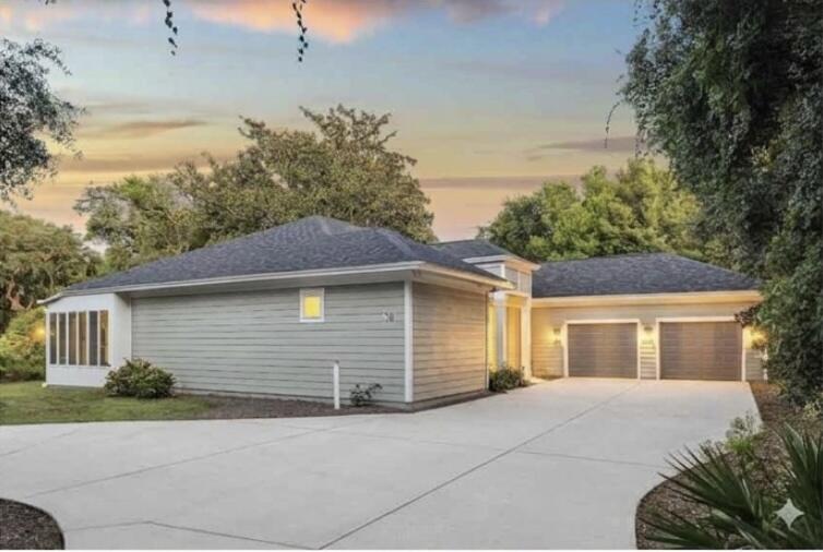 Welcome to this spectacular, move-in-ready coastal retreat, beautifully transformed by a top-to-bottom remodel in 2022. Offering a refreshing escape from Destin's typical high-density, zero-lot-line neighborhoods, this home is nestled on an expansive, private lot shaded by majestic mature oak trees. A sweeping circular driveway provides exceptional curb appeal and ample parking, leading to a finished, oversized garage with a showroom-quality premium floor coating. Inside, complete peace of mind comes standard with a new roof, new windows, and luxury new flooring throughout.Designed with an ideal split floor plan for maximum privacy, the heart of the home centers around a breathtaking chef's kitchen and an inviting living room anchored by a cozy fireplace. The kitchen is an entertainer's dream, featuring a massive quartz island with bar seating, custom gray cabinetry reaching to the ceiling, a contemporary tile backsplash, and a premium gas range. Spanning nearly the entire length of the back of the house is the show-stopping Florida sunroom. Flooded with natural light, this massive bonus space acts as an airy secondary living room, effortlessly drawing the tranquil, treed outdoor setting indoors.Retreat to the luxurious primary suite, a private sanctuary boasting its own romantic fireplace and two spacious walk-in closets. The master bath is fully updated, offering a separate soaking tub and walk-in shower alongside a double vanity layout for ultimate convenience.  The secondary bathroom is equally updated with modern, high-end finishes. In addition to the three dedicated bedrooms, a flexible private home office easily serves as a fourth bedroom, custom home gym, or playroom. The home also features a large, independent laundry room complete with a utility sink.