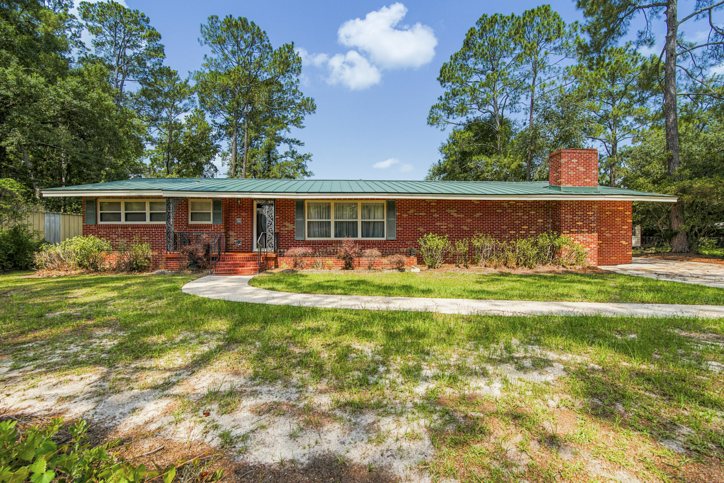 Spacious brick home on 1.5 acres located in the city limits of Geneva, AL - a very rare find. Home features 4 bedrooms and 2 bathrooms, kitchen plus breakfast room, formal living room, separate dining room, laundry room plus large step down family room with fireplace. Abundance of cabinets in the kitchen/breakfast i. Also on the property is a 30x30 workshop/storage building. Property extends from Dogwood Dr to Trinity St with paved drive through for 2 entrances. Home is conveniently located near shopping and many amenties including restaurants.
