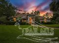 Welcome to 1400 Kings Road, a unique 4-bedroom, 3.5-bath home offering approximately 3,542 square feet of living space on a beautifully landscaped 0.72-acre lot. Designed for both everyday living and entertaining, this home features a spacious Florida room with an additional full kitchen, providing endless possibilities for hosting guests, multi-generational living, hobbies, or recreation. Step outside to your private backyard retreat featuring an in-ground pool, hot tub, and screened enclosure with new screening installed in 2025. A large deck within the enclosure offers ample space to create the ultimate outdoor entertainment area. The park-like grounds showcase a tranquil koi pond with a bridge, waterfall, and grotto, along with a pergola and multiple peaceful spaces to garden, relax, and enjoy the outdoors. Additional features include a whole-home generator, tankless water heater, and solar panels. This one-of-a-kind property combines privacy, character, and exceptional outdoor amenities in a convenient Pensacola location.