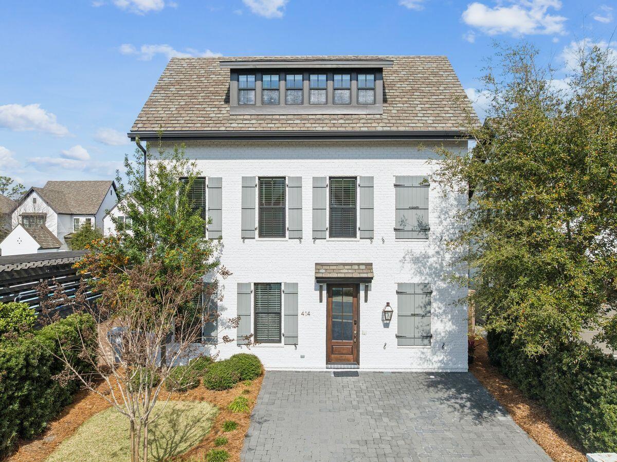 Located in the heart of Santa Rosa Beach along Scenic Highway 30A, 414 Ridgewalk Circle offers a thoughtfully designed three-story coastal home that blends timeless architectural style with comfortable living spaces and close proximity to some of the area's most desirable destinations. Positioned within a charming and manicured neighborhood and just steps from the community pool, the home provides convenient access to neighborhood amenities while maintaining a quiet residential setting.

The exterior features white-painted brick with classic shutters, giving the home a clean coastal look with timeless curb appeal. Upper-level windows highlight the private primary suite that occupies the entire third floor. The property's location within the community places it directly next to the neighborhood pool and pavilion, adding to the convenience and lifestyle appeal of the home.

Inside, the first floor serves as the main living level, designed for both everyday living and entertaining. Approximately 10-foot ceilings and engineered hardwood flooring in a white oak finish create a bright and open atmosphere throughout the space. Recessed lighting and an integrated sound system add comfort and functionality, while a brick accent wall adds character to the living area. A door from the living room leads to the rear patio, creating an easy connection between indoor and outdoor spaces with an outdoor fireplace.

The kitchen and main living area flow together seamlessly, featuring quartz countertops, shaker-style cabinetry with soft-close hardware, and Frigidaire Professional line appliances. A four-burner gas cooktop is paired with a matte arabesque tile backsplash, and a Kohler sink with designer faucet sits beneath a window that brings natural light into the workspace. This level also includes a half bath with Kohler fixtures and a storage space tucked beneath the staircase.

The second floor includes two guest bedrooms, each with its own bathroom, providing comfortable accommodations for family and visitors. Each bedroom has a private bath featuring quartz countertops, porcelain tile finishes, and vanity lighting. One bath contains a combination tub/shower, while the other has a walk-in shower, both with coordinating Kohler fixtures. This level also includes a laundry closet with LG ThinQ washer and dryer.

The third floor is dedicated entirely to the primary suite, creating a quiet retreat separate from the main living areas. The bedroom features six windows that allow abundant natural light, along with the same white oak flooring found throughout the home. Ceiling fans, recessed lighting, and the integrated music system continue on this level. The primary bathroom features a double vanity with Kohler sinks, shaker-style cabinetry, and elegant vanity lighting, complemented by fixtures with a brushed bronze finish. The walk-in shower is finished in marble and includes both a rain shower head and handheld fixture, creating a spa-inspired setting. Large-format tile flooring and a window that provides natural light further enhance the space.

This level also offers excellent storage, including attic space with spray-foam insulation that houses certain mechanical components while still providing usable storage. A small flexible sitting area or reading nook provides additional versatility, ideal for a compact office or private retreat.

Just steps from the home is the Ridgewalk Circle community pool, featuring zero-entry access, decorative water features, a hot tub, and lounge seating for relaxed outdoor enjoyment. A nearby covered pavilion with picnic tables, seating areas, two gas grills, and two televisions provides a convenient space for outdoor meals, gatherings, or watching a game with friends and neighbors.

Beyond the neighborhood amenities, the home's location places it less than one mile from the Ed Walline Regional Beach Access, offering easy access to the white-sand beaches and emerald waters of the Gulf. The property is also conveniently located near the shops, restaurants, and entertainment at Gulf Place, along with popular dining spots such as Shunk Gulley. Scenic Highway 30A's walking and biking paths, boutique shops, and vibrant coastal atmosphere are all just moments away.