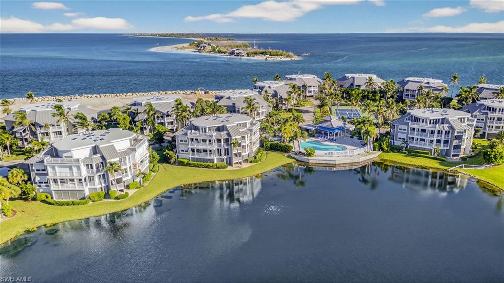 At the northernmost tip of Captiva Island, where the turquoise waters of Redfish Pass flow gracefully between the Intracoastal Waterway and the shimmering Gulf of Mexico, awaits one of Florida’s most coveted enclaves. Tucked behind the private gates of the world-renowned South Seas Resort lies Land’s End Village, an intimate retreat of just 17 buildings, each thoughtfully designed with only four residences above covered parking. This rare collection offers an exclusive lifestyle in one of the Gulf Coast’s most breathtaking settings. This beautifully appointed 2-bedroom, 2-bath residence embodies comfort and sophistication. An open-concept kitchen flows seamlessly into the living space, where walls of glass invite the outdoors in. Expansive screened lanais frame sweeping views of emerald fairways, glistening lakes, and the shimmering waters of the Bay and Gulf beyond, bringing the essence of island living to every corner of the home. The large primary suite offers a spacious bathroom and breathtaking views. Land’s End Village is more than a residence, it’s a lifestyle. Owners enjoy a private pool and spa in a breathtaking setting, fitness center, tennis and pickleball courts. Here, every moment feels like a postcard. Watch sailboats drift effortlessly along the Intracoastal, cast into world-class fishing grounds at Redfish Pass, or stroll Captiva’s powdery white sands as the sun melts into the Gulf—painting the sky with unforgettable sunsets that have become a cherished nightly ritual. Beyond the shoreline, the lush greens of a manicured golf course and tropical landscapes create a vibrant backdrop worthy of a travel magazine spread. The South Seas Resort itself is undergoing an extraordinary transformation. Soon, residents and guests will experience enhanced dining, a full-service marina, family-friendly waterparks, an executive golf course, and countless new amenities that redefine luxury resort living. Whether envisioned as a private coastal sanctuary or an enticing investment opportunity in the thriving vacation rental market, this residence offers unparalleled flexibility—free of current rental management commitments. It is an invitation to be part of the revitalization of one of Florida’s most iconic resorts and to own a piece of paradise at the water’s edge.