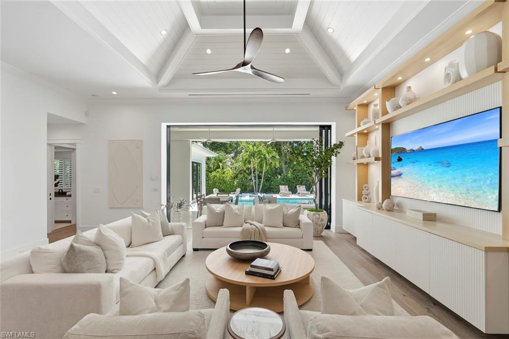 Thoughtfully designed by renowned architect Falconer Jones, this newer construction Lake Park home is just minutes to downtown Naples, with walkability to 5th Avenue and the beaches, offering modern coastal living with high-end finishes and seamless indoor-outdoor flow. The floor plan is ideal for entertaining and family gatherings, with wide-plank wood flooring throughout, designer tile, and curated finishes that give the home a clean, modern feel, while vaulted ceilings create volume and natural light across the main living spaces. The chef’s kitchen features custom KBC cabinetry, a large center island with pendant lighting, 36” gas cooktop, Samsung and Dacor appliances, and a wine cooler—designed for both everyday living and entertaining. The outdoor living space is a true highlight, featuring a south-facing gas-heated pool that enjoys sun all day, along with a water feature, covered lanai with roll-down screens, outdoor kitchen with gas grill, and outdoor shower—creating a private resort-style setting. Built with concrete block construction, PGT impact windows, and a standing seam metal roof for durability and peace of mind, along with an air-conditioned garage offering flexible use and added comfort. Located in the highly sought-after Lake Park neighborhood, just minutes to downtown Naples and 5th Avenue, in the heart of Olde Naples.