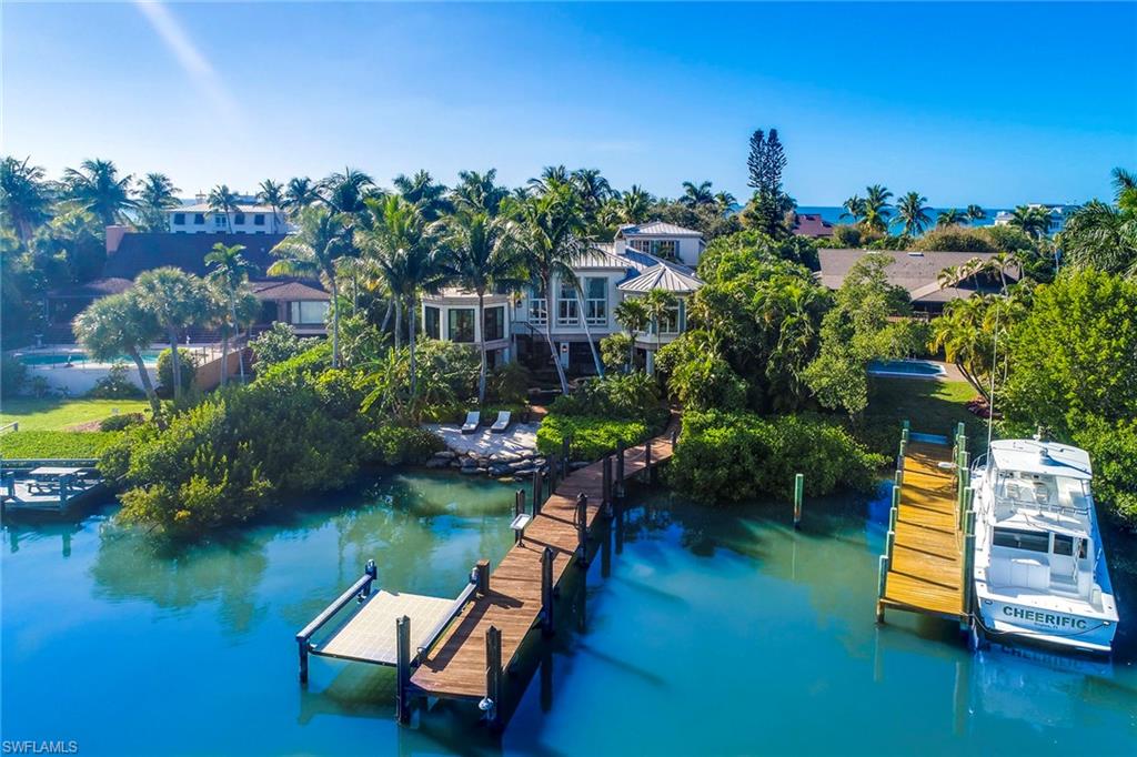 A magnificent custom residence overlooking the open waters of Champney Bay and protected preserve. Qualifying for an immediate Port Royal Beach Club membership and exclusive beach access, this one-of-kind property offers unprecedented architecture and exquisite details. Infused with a Caribbean flair, the tropical grounds with koi ponds, mature vegetation, and covered verandas evoke privacy and calm. The sprawling property consists of multiple structures designed by noted architect Jeff Harrell and completed by Hemmer Construction and BCB Homes. The main house offers three extraordinary levels, immerse by water views and natural light. Coral stone, beadboard walls, tin ceiling details, walnut and marble floors, custom built-ins, and artful chandeliers highlight the spaces while a separate guest house with media room/living, three guest suites, morning kitchen and extended patio offer privacy and comfort. The main outdoor living accentuates resort living immersed by tropical gardens, pool with waterfalls, double-sided fireplace, full kitchen, and dining areas, perfect for entertaining. A private boat dock with lift complete this extraordinary home.