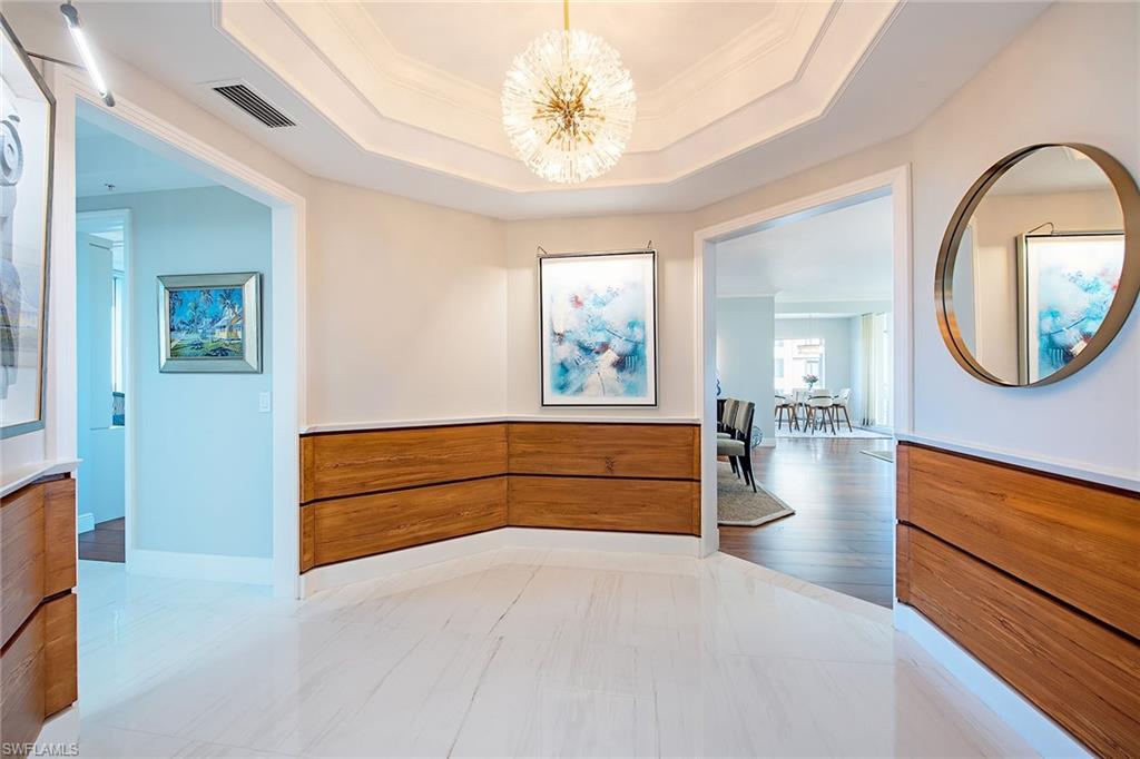 Arrive home in style with private elevator access that opens directly into your residence. Offering 2,800 square feet of fully renovated living space, this exceptional home blends sophisticated design with unmatched comfort. The spacious floor plan includes three bedrooms, three elegantly appointed baths, highlighted by 10-inch walnut flooring, 9-foot ceilings, designer wall coverings and all new lighting throughout. The chef-inspired kitchen is a showpiece with quartz countertops, premium stainless steel appliances and refined modern hardware. The remastered primary suite provides a serene retreat, featuring a luxurious soaking tub, illuminated mirrors, and a large picture window showcasing breathtaking views of the bay and Gulf. Enjoy outdoor living at its finest with two expansive wraparound lanais, one east-facing for peaceful sunrises, one west-facing for spectacular sunsets. Two dedicated parking spaces and an air-conditioned storage locker convey. In the beautiful, fully renovated Toscana at Bay Colony.