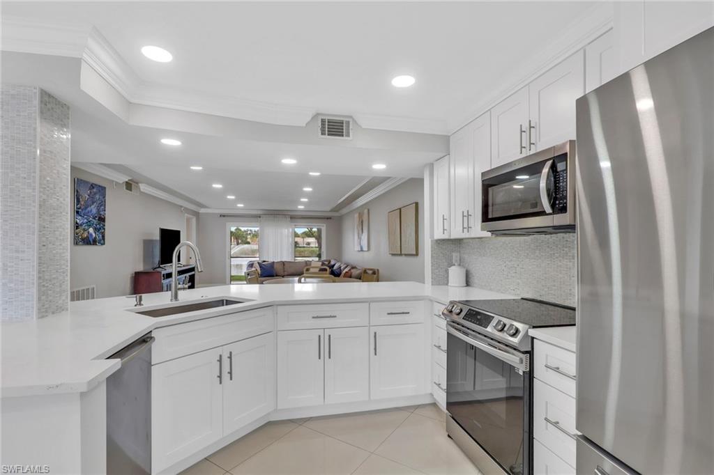 Enjoy serene lake views in this beautifully renovated first-floor condo offering refined style and comfort.  Meticulously maintained and move-in ready, the home showcases elevated finishes throughout, with all improvements professionally and fully permitted.  The stylish kitchen boasts quartz countertops, soft-close cabinetry, modern lighting, and a brand-new refrigerator, creating a space that is both functional and visually striking. Light-filled, open-concept living areas are enhanced by elegant crown molding and abundant natural light, delivering a warm yet sophisticated ambiance. Tile flooring extends through the main living spaces, while rich wood flooring adds warmth and character to the bedrooms.   Top rated schools, just minutes from Mercato, Vanderbilt Shoppes, Sam’s Club, premier dining, medical centers, and Naples’ world-renowned beaches.  A rare opportunity, perfectly suited for first-time homebuyers or as an elegant vacation retreat, where quality, convenience, and lifestyle come together seamlessly.