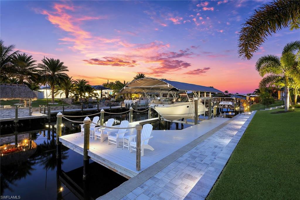 A rare collaboration between custom construction and a professional interior designer, this 2022-built waterfront residence in SE Cape Coral represents one of the most thoughtfully curated and meticulously finished homes to come to market. Sold furnished and offering 3 beds plus a dedicated office, 3 full baths, a 3-car garage, and 2,292 SF of bespoke, light-filled living space. The construction, the dock, and the high-end furnishings are impossible to replicate at today's costs. The open-concept living space features soaring vaulted & tray ceilings, and the impressive 20-foot pocketing sliders and French doors blur the line between indoor and outdoor living, filling the home with vibrant water views and evening sunsets. Hurricane impact windows and doors provide complete storm protection throughout. The architectural finish work matches the furnishings at every turn. Custom millwork on the foyer and living room ceilings, custom millwork added to all window and door openings, custom millwork in the dining room, professionally designed luxury interior lighting throughout, custom all-wood closet systems in every closet, professional custom window treatments, and Top Knob cabinet hardware throughout create a high-end interior. The chef's kitchen is appointed with Pottery Barn stools, quartz countertops throughout, a custom tiled backsplash, a double oven, and Top Knob cabinet hardware. The primary suite offers 2 walk-in closets with closet systems and a spa-inspired ensuite with an oversized shower, soaking tub, and a large vanity. Waterfront guest bedroom features its own ensuite bath plus an additional guest bed, full bath, and a dedicated office with a custom bookshelf feature wall straight out of a magazine! Your oasis awaits. The 14x30 saltwater heated pool with sun shelf and bubbler, integrated spa, LED lighting creates a private resort setting. A 14K-pound lift, 30-ft slip,10-ft 6-in beam, with quick open-water access in just 2 turns and 1 bridge to the river — from there, waterfront dining, beaches, and fishing. Wear Deck dock w/ 13.5-ft sunset observation deck overlooking the intersection of the canals. A basin-like western waterfront view that produces stunning sunsets every single evening. This is not a resort - this is your home! Every design selection was intentional and hand-curated. Restoration Hardware, Serena and Lily, Arhaus, and more complete the curated furniture selection (list available). HVAC w/Infrared system & generator hookup. Located near the most exciting new developments. The $225 million Cape Coral Yacht Club Community Park redevelopment is delivering a new riverfront beach, resort-style pool, marina, & dining. Newly reimagined Jaycee Park just opened, w/a splash pad, beach volleyball, a boardwalk, and live events. Slipaway Food Truck Park and Marina, The Cove at 47th with its rooftop Sky Bar, and the newly opened Bimini Square — featuring waterfront dining and a Lee Health outpatient clinic.