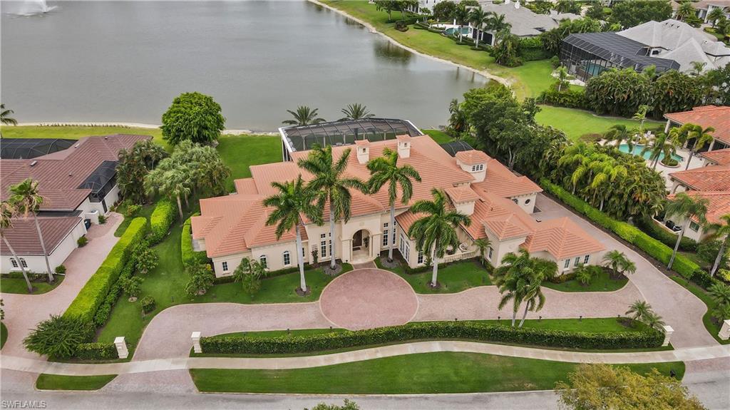 This Mediterranean style grande estate home has a sensational 11-acre lake view! Master suite provides a private room for massage table, exercise equipment, or etc. Master bathroom has his and hers vanities with his and hers walk-in closets. 18' foot ceilings and an open floor plan with an elegant living room and family room separated by floor to ceiling fireplace and wet bar. Formal dining room and large morning room are separated by the butlers pantry.  4-car garage with a very long circle driveway for extra parking. Expansive outdoor screened-in lanai with outdoor kitchen and fireplace.  Quail West Country Club provides top-of-line amenities including 8 har-tru lighted tennis courts, 2 championship golf courses, 2-story fitness center, indoor and outdoor dining, full service salon, indoor pool and spa and so much more.