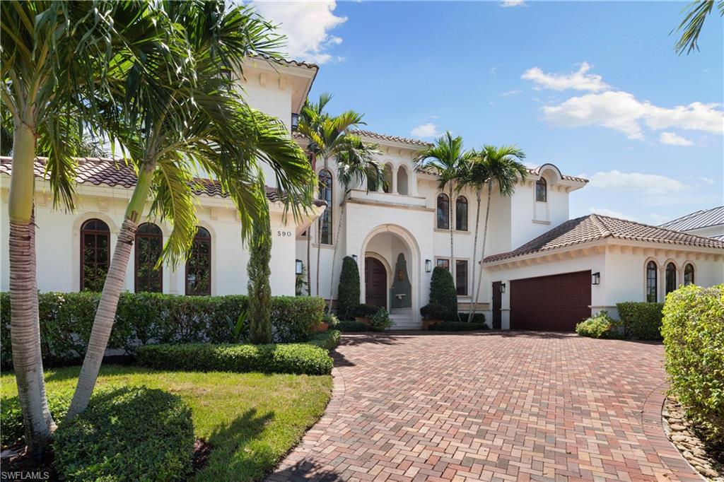 Best Waterfront Value in Aqualane Shores – Hurricane-Resistant Southern Exposure Estate with Boat Dock at 11.1 ft Elevation. This is the best waterfront deal in Aqualane Shores—a custom-built, hurricane-resistant residence positioned at a rare 11.1 feet above sea level, offering Southern exposure, low-maintenance living, and transferable flood insurance premiums. Located on the quiet and highly coveted 17th Avenue South, just a short stroll to the beach and the charm of 3rd Street South, this home offers over 5,800 sq. ft. of luxurious indoor living space with 6 en-suite bedrooms and 7.5 bathrooms, designed for comfort, privacy, and effortless entertaining.
Step inside to soaring ceilings and elegant finishes throughout. The gourmet kitchen is a chef’s dream, featuring a gas stove, Sub-Zero refrigerator, double dishwashers, icemaker, walk-in pantry, and a large center island—all seamlessly flowing into the warm and inviting living room with a cozy gas fireplace. A climate-controlled wine cooler is beautifully showcased near the curved staircase, adding sophistication to the entertaining experience.
The first-floor primary suite offers a tranquil retreat with private access to the pool and Jacuzzi, dual walk-in closets, and a spa-like bathroom. Upstairs, five additional guest suites are accompanied by a media room, exercise room, and a spacious wraparound balcony that enhances the indoor-outdoor lifestyle. Outside, the expansive lap pool and spa are surrounded by a luxurious outdoor living area complete with a summer kitchen—ideal for hosting or relaxing in privacy. The new dock includes a boat lift, two Jet Ski lifts, a seating area, and provides direct deep-water access to Naples Bay and the Gulf of America. Additional highlights include a 3-car garage, secondary staircase to the west wing, and a professional Home Watch Service keeping the home in pristine condition. This is a rare opportunity to own one of Naples’ finest waterfront homes, combining elevated construction, prime location, and exceptional value.