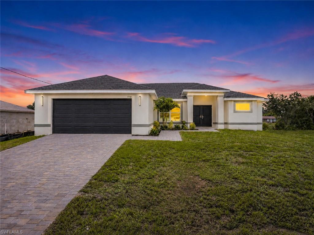 Looking for a brand-new, move-in-ready home? Your search ends here! This beautifully designed home offers over 1,600 square feet of thoughtfully planned living space with 3 bedrooms plus a versatile den, all situated on a desirable corner lot overlooking a freshwater canal in a convenient NE Cape Coral location. Best of all, the home is not located in a flood zone, so flood insurance is not required by most lenders, and with impact windows and doors, it gives you some added peace of mind. Step inside to discover elegant tile flooring throughout and a bright, open floor plan designed for both everyday living and effortless entertaining. The spacious kitchen is the heart of the home, featuring raised-panel wood cabinetry with soft-close drawers, gorgeous quartz countertops, stainless steel appliances, and a generously sized pantry. A welcoming dining area flows seamlessly into the great room, creating the perfect space for gathering with family and friends. The spacious primary suite is a private retreat with a tray ceiling, sliding glass doors leading to the lanai, and two walk-in closets. The primary bathroom features dual sinks and a beautifully tiled walk-in shower. The generously sized guest bedrooms also feature tray ceilings for an added touch of elegance. The versatile den includes a closet and offers endless possibilities as a home office, playroom, hobby room, media room, or flex space to fit your lifestyle. An interior laundry room adds everyday convenience. Step outside to enjoy peaceful freshwater canal views from the lanai, while attractive paver accents enhance the paver driveway, walkway, and front entry, creating outstanding curb appeal. The home is connected to city water and sewer, with the buyer to assume the remaining balance of assessments and related fees. Beautifully finished and thoughtfully designed, this exceptional new home is ready for you to enjoy the Southwest Florida lifestyle.