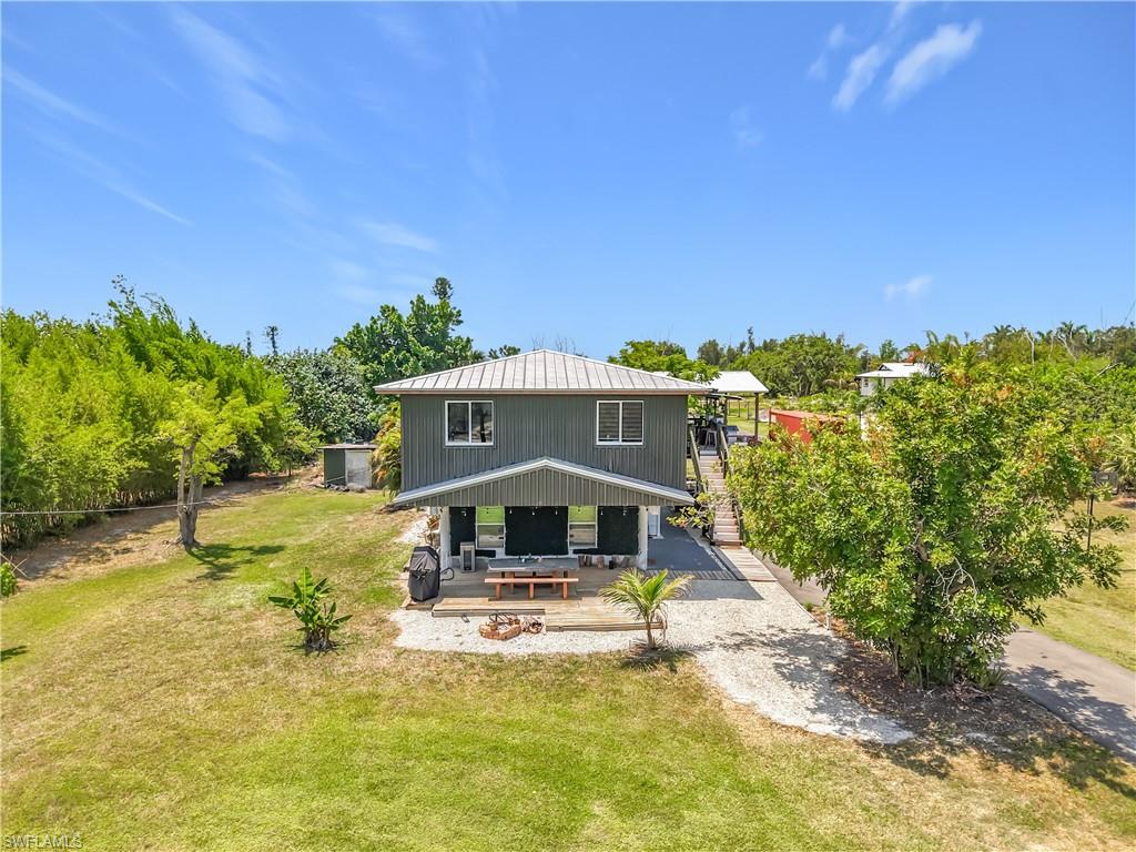 Island Retreat with Income Potential on a Full Acre! Tucked away on a private 1-acre agricultural lot in Saint James City, this two-story home offers a great mix of peaceful country living and proven rental flexibility. The upstairs features an open living layout with lots of natural light, white kitchen cabinets, butcher-block countertops, and a full bathroom with a soaking tub. Outside, the property features a durable metal roof and a huge yard with no HOA restrictions, giving you plenty of room to build a pool, put up a pole barn, or park your boats, trailers, and RVs. What really makes this property stand out is the enclosed downstairs space, which has a successful history as an Airbnb rental. This self-contained studio is completely separate and comes ready to go with its own kitchen setup, navy cabinets, and a custom bathroom with a glass walk-in shower. Outdoors, there is a large wooden deck and a fire pit area that's perfect for entertaining. Whether you want to live upstairs and let the downstairs pay your mortgage, use it for family, or add it to your rental portfolio, this Pine Island property offers a ton of options.