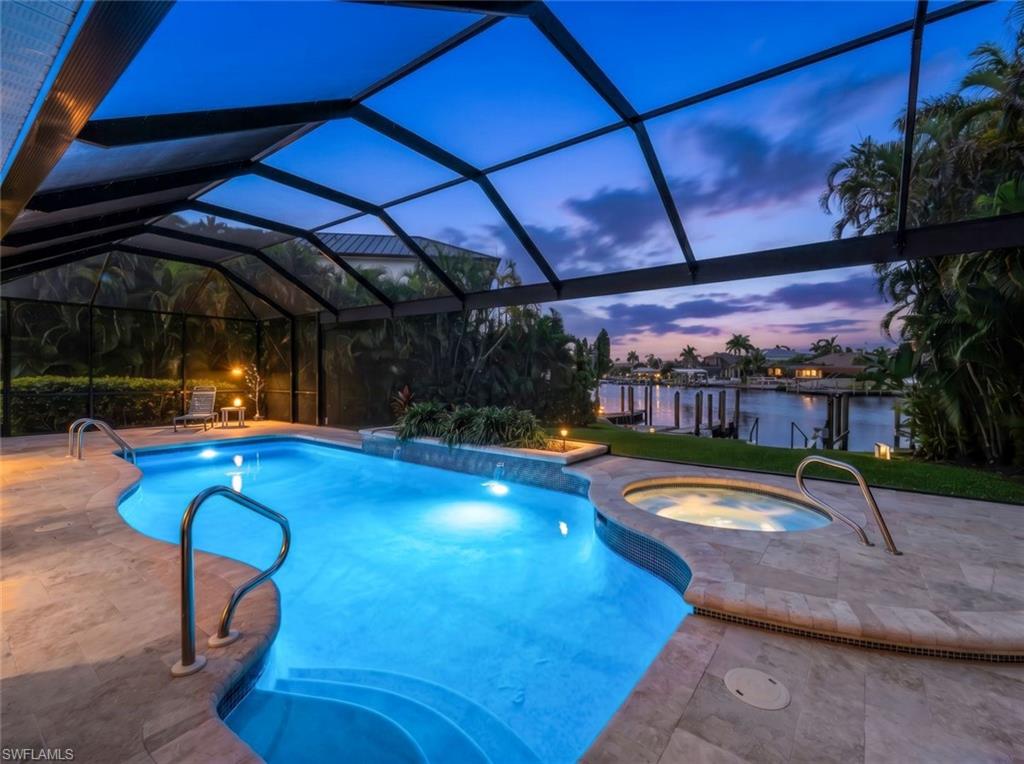 Welcome to this exceptional Cape Harbour residence offering luxury waterfront living on an oversized lot with direct sailboat access and an estimated 15-minute boat ride to open water. Designed for both comfort and entertaining, this beautifully appointed home blends elegant finishes, thoughtful details, and a private resort-style atmosphere.

The interior showcases three spacious en-suite bedrooms with spa-inspired bathrooms, a stunning chef's kitchen featuring a quartz waterfall island, GE Café appliances, breakfast nook, and formal dining area. Expansive living spaces, soaring ceilings, crown molding, and refined finishes create a bright and sophisticated feel throughout. The first-floor Grand Master Suite is a true retreat, featuring a spacious sitting area, an imported Czech glass chandelier, private loft access via an impressive staircase, wet bar, and dedicated library and office space.  The Grande Master Suite can be converted in kids room with that sleeps 8 with entertainment loft making it the perfect vacation rental home. The home also offers flexible living space that can easily be transformed into a fourth bedroom or additional private retreat.

Step outside to your own private oasis with a beautifully designed lanai featuring covered dining and entertaining areas, a saltwater pool and spa, sun deck, pool bath, outdoor shower, grilling area, and a spacious screened pool enclosure. Mature landscaping — including 13 stately Royal Palms — surrounds the property, providing added privacy and a true tropical ambiance.

Boaters will love the direct sailboat access waterfront location, newer composite dock equipped with a Seahorse Docking Roughrider system, and a quick approximately 15-minute ride to open water, making it easy to enjoy everything Southwest Florida has to offer.

Car enthusiasts will appreciate the oversized three-car garage with epoxy flooring, electric vehicle hookup, two large driveways, and ample parking for vehicles, toys, or guests. Additional highlights include major renovation - a tile roof installed in 2023, three well-maintained HVAC systems, stamped concrete driveway, pre-wiring for security and generator systems, and meticulous attention to detail throughout. Located in the sought-after Cape Harbour community, this home delivers the perfect combination of waterfront access, luxury amenities, and a true Florida lifestyle.