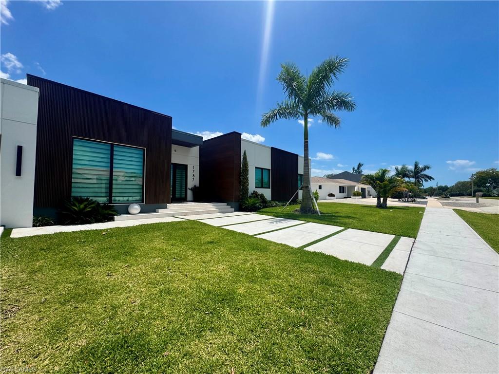 Miami Vice or LA Elegance?  This contemporary home astonishes on the inside. Built in 2024, this fresh style home feels new throughout.  If you like modern design, finishes, clean minimalist lines and furnishings to match,  this home should be top of your must see list. Located at high elevation on a ridge top, tucked away on a quiet street, this home design provides privacy and peace of mind.  Walk in through large format dual glass entry doors. Impact windows & sliding doors with upgraded glass whoosh the interior with abundant natural light.  White porcelain tile flooring throughout polishes every room and hallway. Oh, and this kitchen is elegant, sleek, and functional with floor to ceiling cabinets,  island counter & seating, separate dining table area connecting the flow into the media/family room. It puts all the people together for social activities in one wing of this smart layout.   The design carefully wraps around an infinity edge app controlled heated pool with hot spa in the courtyard nestled in the sunshine or night sky between the wings of the home. Three AC systems insure comfort where its desired.  Marco Island’s world famous 4 mile crescent beach is a short hop away.  As a resident, you can join and enjoy our 15 acre Residents members only beach with café, showers, grills, bbq, shade chickees, parking and more. This home is currently a popular rental so if you’re looking for income with a home in paradise, you have it.  If you want your own place without sharing, that’s’ possible too.  It’s an oasis – inside and out.  Come check it out.