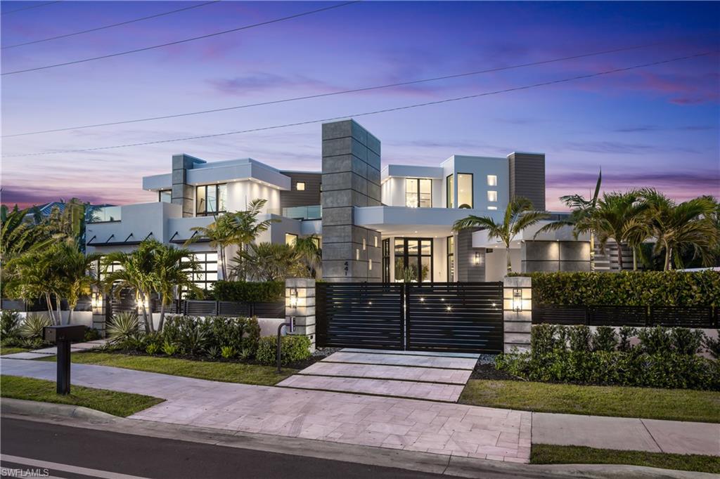 One-of-a-kind masterpiece built in December 2022 (nearly 2023) in the highly sought-after Moorings neighborhood of Naples with breathtaking bay views. Just a 10-minute walk (0.4 miles) to the beach, this architectural marvel offers an unparalleled coastal living experience. As a Moorings resident, you are eligible for membership (at a very low cost) to the exclusive Moorings Beach Park for effortless beach access. This modern estate was custom-built by the award-winning Potter Homes & expertly designed by Adelyn Charles Interior. Designed for the utmost privacy & exclusivity featuring electric motorized entry gates, a solid fortress-like construction of all concrete block, hurricane impact windows/doors throughout & electric hurricane shutters. Every aspect of this property has been crafted with the finest materials & attention to detail, including stunning oak flooring, reverse tray ceilings with wood paneling/uplighting & soaring 14-ft ceilings. Part of the exclusive “Golden 50” in the Moorings, with direct, bridge-free access to the Gulf in just 5 minutes via Doctors Pass. For boating enthusiasts, the home is equipped with dual lifts—one featuring a 30 ft boat lift with a 16,000 lb weight capacity, and the other for dual jet skis. The outdoor living space is a true paradise, with a luxurious pool and spa, fireplace, sun deck with built-in firepit, and a fully equipped summer kitchen perfect for al fresco dining. With 12 ft pocketing floor-to-ceiling sliders, the space effortlessly blends the interior and exterior for seamless waterfront living. Inside, this expansive estate offers 6,900 sq ft under air with 6 bedrooms, 6 full bathrooms (all with dual vanities), 3 half baths, a separate guest house, 3 laundry rooms & a 3-car garage. The state-of-the-art kitchen is a chef’s dream, with custom white cabinetry, dual wood islands with waterfall concrete overlays, high-end Thermador appliances & a butler’s pantry. The main-level primary suite is a private retreat, complete with custom wood ceilings, a wet bar, massive walk-in closets, and a spa-like bathroom with dual vanities, dual water closets, a generous shower with multiple showerheads, dual benches & a separate soaking tub. Upstairs, a spacious living room area with a wet bar, island with bar seating & 3 bedrooms create the perfect space for relaxation, while a sundeck provides breathtaking water views. For ultimate guest privacy, the separate guest villa offers a bedroom, ensuite bathroom, laundry room, full kitchen & private sundeck—ideal for hosting guests. Another highlight of this home is the rooftop observation deck offering sweeping views of the Gulf & Bay—perfect for sunset vistas. Additional features include a private elevator, buried gas propane tank, electric screens, lush landscaping, a spacious front yard ideal for pets & more. An extraordinary sanctuary in one of Naples' most coveted communities, The Moorings, this residence is truly a showcase of visionary design.