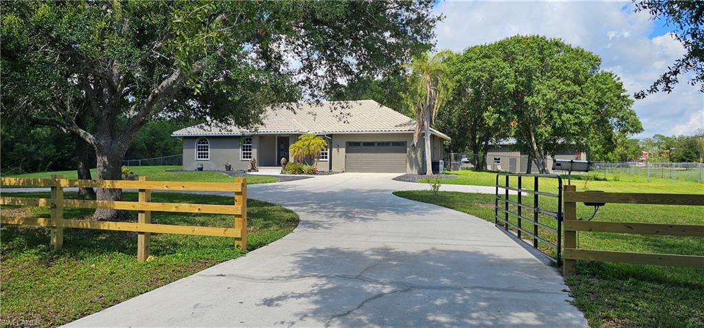 Live the Southwest Florida lifestyle on your own private 2.24-acre fenced estate, complete with a stocked fishing pond, heated pool, and expansive workshop. This beautifully updated 4-bedroom, 2-bath pool home (plus a dedicated office/library) offers over 2,100 square feet of air-conditioned living space. Featuring a Spanish tile roof, circular driveway, automatic entry gate, and attached 2-car garage. The property also includes a large 40'x 45' professional-grade workshop/garage featuring two 22' garage doors with ample room for multiple vehicles, boats, and all your toys. Inside, the home welcomes you through a double door entryway into a bright, open-concept living area with soaring ceilings and new Pergo flooring throughout. The fully remodeled kitchen boasts quartz counters, a gas range, two pantries and stainless steel appliances, overlooking the main living space. The spacious master bedroom suite offers a custom walk-through closet and a luxurious ensuite bath with a large tiled walk-in shower and dual sinks. Outside, relax by the heated swimming pool or enjoy the peaceful pond stocked with fish and visiting ducks. Gather fresh eggs from the chicken coop, and take advantage of the animal barn, tankless water heater, pool heater, generator hookup, and automatic sprinkler system. Horses OK here with no HOA fees or rules. Experience the best of country living with easy access to some of southwest Florida’s finest beaches, dining, and entertainment. Located in Flood Zone X — no flood insurance required!!!