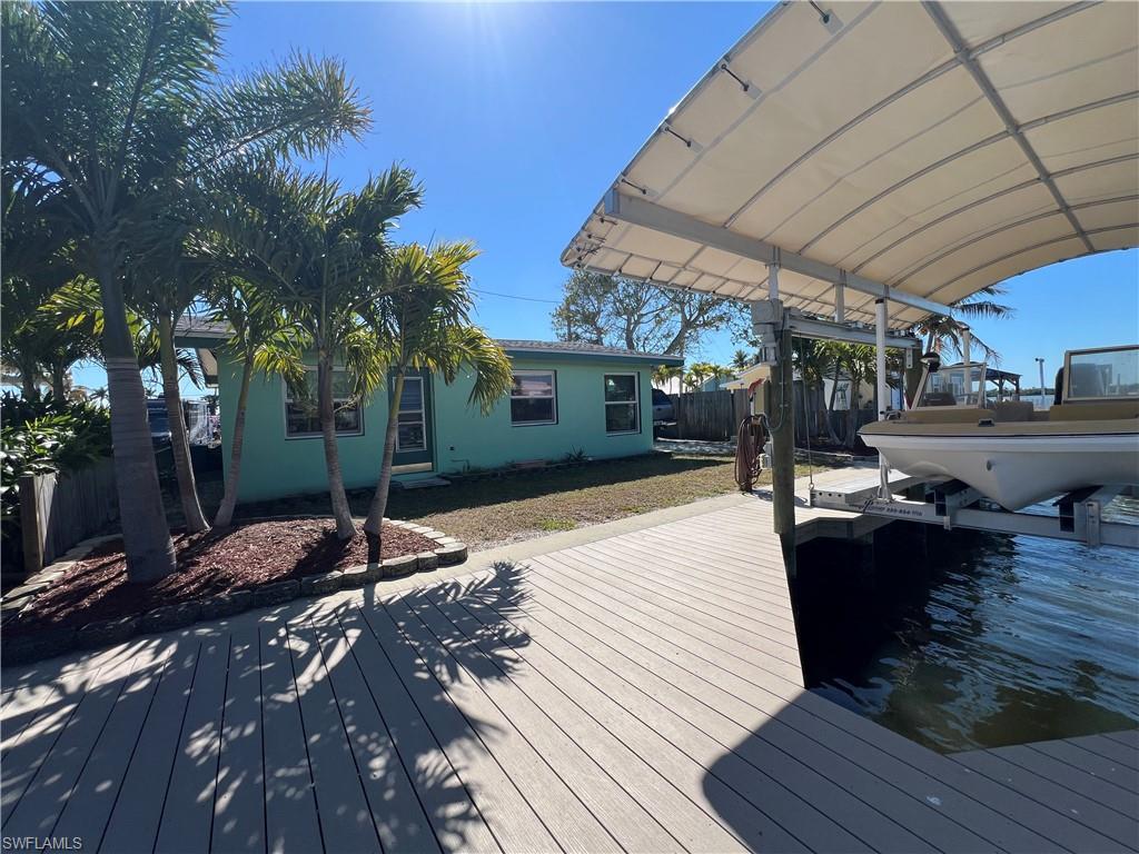 This canal front residential property is located at 2650 Coco Plum Drive in Cape Coral, Florida, within the Matlacha area of Lee County. The property sits along a saltwater canal that provides access to surrounding waterways consistent with local conditions and navigational regulations. Matlacha is a coastal community positioned between Pine Island and the mainland, known for its compact layout, waterfront setting, and connection to nearby fishing areas and barrier islands. The residence on the property is a single story cabin style home featuring one bedroom and one bathroom. A garage is included, offering enclosed parking and storage. The garage is equipped with a hurricane rated garage door designed to meet applicable wind resistance standards. The home is situated on a canal front lot with established shoreline improvements that support marine use. Along the water frontage, a seawall was newly constructed in 2020. A dock and boat lift were also installed in 2020, providing direct access to the canal. The boat lift includes a canvas cover, which offers protection for a vessel when not in use. Water depth, vessel suitability, and navigability should be independently verified by prospective buyers based on intended use and seasonal conditions. The roof of the home was replaced in 2021 prior to Hurricane Ian. According to the information provided, the structure did not sustain roof damage during that storm. Buyers are encouraged to conduct their own inspections to confirm the condition and remaining service life of the roof and all other improvements. The canal system connected to the property leads toward open water areas that are commonly used for boating and access to nearby fishing flats and coastal waters. The waterways also provide routes for traveling by boat to nearby islands and beaches, subject to local regulations, tides, and weather conditions. No representation is made regarding travel times or water conditions. The property is located within walking distance of local dining establishments, retail shops, and art galleries in Matlacha. The area is known for its locally owned businesses and pedestrian friendly layout. This setting allows residents to access nearby amenities without reliance on long drives while remaining connected to the broader Lee County region. Road access to the property is provided by Coco Plum Drive, a maintained residential roadway. Utilities serving the home are consistent with other residential properties in the area, though buyers should verify specific service providers and availability. Any future modifications, expansions, or changes in use should be reviewed with Lee County and applicable local agencies to ensure compliance with zoning, building, and environmental regulations. This property may be suitable for buyers seeking a small waterfront residence with established marine infrastructure in a coastal Florida community.