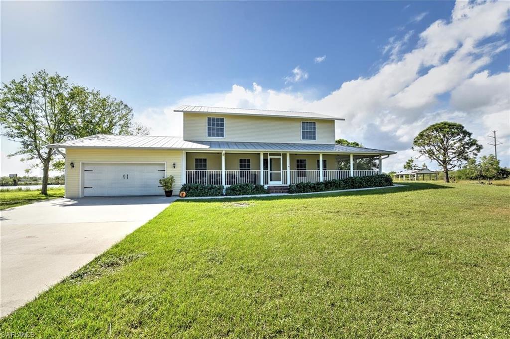 Custom Built Country-Style Pool Home on 2.37 acres of land.  This is a beautifully manicured lot with mature Oaks, and includes partial ownership of the rear lake, where you can kayak, jet ski and fish! The house is concrete block on the first level, wood frame on the 2nd level, with a metal roof, and a completely enclosed wrap-around porch.  There is a large screened-in patio in the rear, with a 14x28 pool and a good-sized under truss area for lounging or dining.  Designed by the current owner, this inviting home has custom yellow pine flooring, crown molding, wainscoting, Wilsonart solid surface counters, and solid wood cabinetry.  The master bedroom is on the first floor, with a private door to the pool area, 2 walk-in closets, and includes an ensuite bathroom with a walk-in shower, soaking tub and dual sinks.  Upstairs are 3 more spacious bedrooms + a HUGE loft area that can be converted into a 5th bedroom (there is a closet) or a den, office or playroom.  This property provides the perfect setting to raise your family with plenty of space, inside and outside.  Situated just 5 minutes from I75, close to shopping and restaurants on Bayshore Rd. and about 15 minutes from Downtown Ft. Myers, you can enjoy a country setting just a quick car ride from all your necessities!