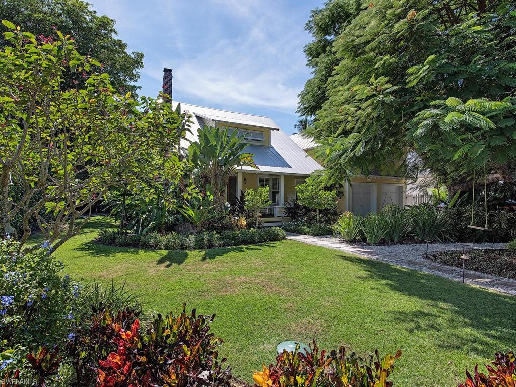 Filled with every ounce of warmth, character, and history, the 1929 Captain Parker House captures the dream of Olde Naples and is located just steps to Cambier Park, 5th Avenue South, 3rd Street South, and Naples' sugar sand coastline. Having been fully restored over the years to create a perfect marriage between history and modern-day elegances, the romantically-set cottage features a gracious front porch, old-growth heart pine flooring, a fireplace enveloped in hand-picked oyster shells, ship-lap walls, whimsical tiling, stunning soaking tub, grotto style pool, and Hardie board siding. A number of other luxurious features are encompassed, such as a chef’s kitchen outfitted with a Lacanche gas range, Sub-Zero refrigerator and wine cooler, as well as a whole-house generator, impact glass, and a metal roof. The remainder of the parcel is enveloped in lush tropical foliage and includes vegetation such as a 50' Royal Poinciana tree, birds of paradise, banana, coffee, and coconut trees, as well as gardenias.