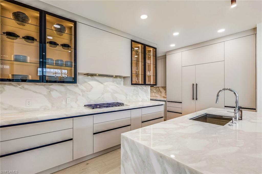 New construction luxury home in Lake Park, just minutes from Downtown Naples, 5th Avenue South, and the Gulf beaches. This custom-built residence offers 4 bedrooms plus a den, 4 full baths, 1 half bath, and 3,253 square feet of thoughtfully designed living space. Filled with natural light, the open floor plan features wide-plank wood flooring, soaring ceilings, and designer finishes throughout. The chef's kitchen is equipped with Sub-Zero and Wolf appliances, custom cabinetry, Italian marble, and a walk-in pantry, flowing seamlessly into the spacious living and dining areas. The first-floor primary suite offers a spa-inspired bath with dual walk-in closets, while the den provides flexible space for a home office or guest room. Outdoor living includes a covered lanai with a fully equipped kitchen, heated saltwater pool, spa, and plenty of space to entertain. Additional features include impact-resistant windows and doors, a private elevator, a 500-gallon propane tank for indoor and outdoor cooking with future generator capability, and a two-car garage. Located in one of Naples' most sought-after neighborhoods, this home offers exceptional access to Downtown Naples, world-class dining, shopping, boating, and the white sand beaches of the Gulf.