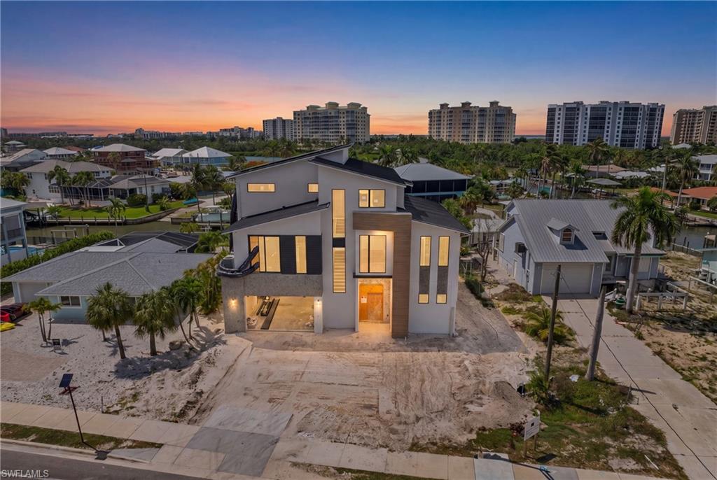 Welcome to Casa Verde Mar, a NEW CONSTRUCTION, certified GREEN HOME built by Imperial Homes, featuring a FULL-SIZE PICKLEBALL COURT with high-end furnishings & interior design by Clive Daniel Home! Ideally located on the highly desirable South End of Fort Myers Beach, this exceptional waterfront residence offers outstanding boating access while redefining modern island luxury. The home provides 4,610 square feet of living space under air with 5 total bedrooms complemented by 5 full baths & 2 half baths, tons of multi level covered outdoor living space, 2,075 square feet of garage & storage space accommodating the full-size pickleball court or a 6 car tandem garage. A massive elevated pool deck showcases a 350-square-foot pool & spa package with a dedicated second-level pool bath, while a brand new seawall, covered boat dock, captain’s walk & boat lift place you just moments from the open waters of Estero Bay & the Gulf. The 1st living level is designed for both everyday comfort & entertainment, featuring an expansive great room, a stunning chef’s kitchen with oversized island & hidden Butler’s Pantry, powder room, wet bar, lounge or office space & an impressive owner’s suite as well as a generous guest suite. Sliding glass doors seamlessly connect the interior to a covered outdoor living area complete with a summer kitchen & pool bath, creating the perfect setting to enjoy the Florida lifestyle. The second living level offers three additional guest suites, including a VIP suite with walk-in closets and a large bath, plus a living area with bar, home office & access to a covered patio. Additional highlights include native landscaping; Aercon lightweight aerated concrete block construction with R-values exceeding code by 20–30%; a solar power system with three 54-kW Tesla battery storage units; electric vehicle charging; full smart home automation & energy monitoring; standing seam metal roof; Sub-Zero and Wolf appliances; Electrolux washer and dryer; 3-zone high-efficiency A/C system; whole-home speaker wiring; & roll-down bug screens & hurricane shutters on covered outdoor spaces. Contact for Full Spec Sheet! Finishes may still be selected for a limited time, offering a rare opportunity to personalize this extraordinary home! Call today to schedule your private showing & start living the SW Florida lifestyle in Paradise Today!