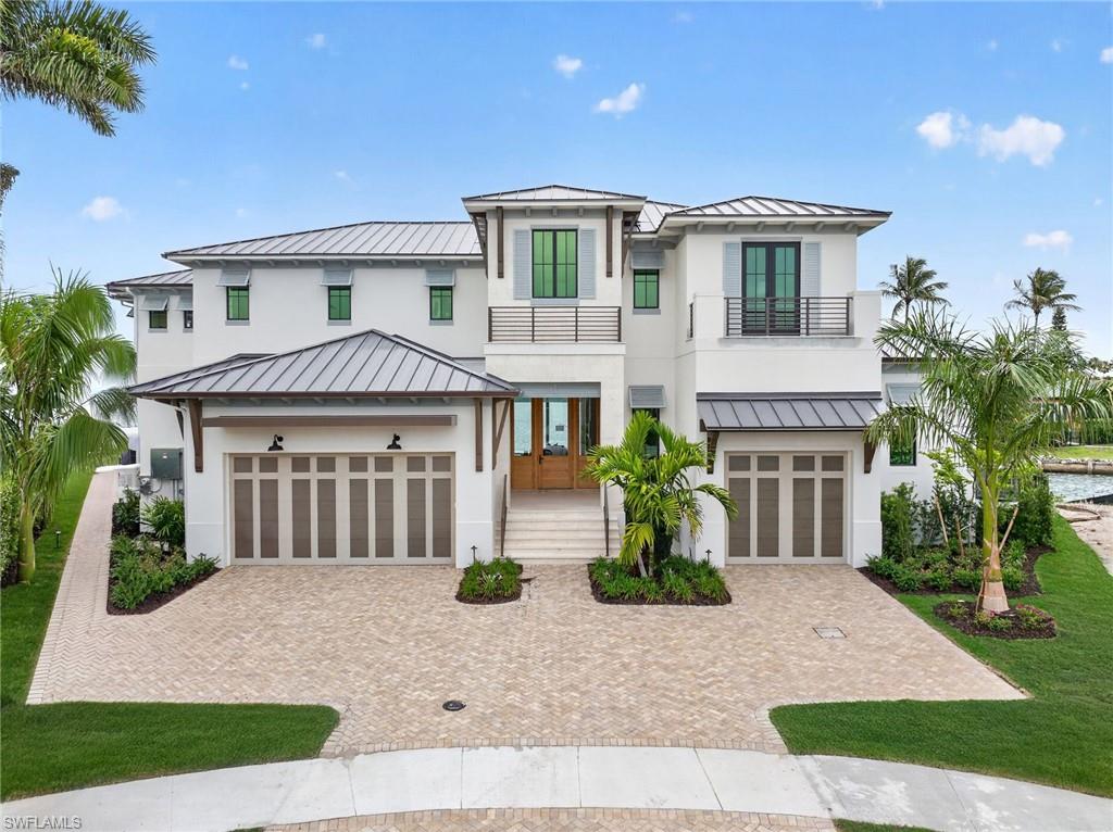 Move in ready! Positioned on one of the few remaining premier waterfront parcels on Marco Island, this new custom estate by The Lykos Group captures over 170 feet of gulf frontage with wide water views and direct Gulf access with no bridges. Located on a quiet cul de sac, the setting offers exceptional privacy while placing you only minutes by boat to the Gulf, Isle of Capri, Marco Island Yacht Club, and the Snook Inn. The surrounding waterways attract dolphins, manatees, and native coastal wildlife, creating a peaceful waterfront setting rarely available on the island. Designed to complement the Marco Island boating lifestyle, the residence offers 6,230 square feet under air and nearly 7,800 total square feet. The layout includes five bedrooms plus a den, seven bathrooms, a club room, loft, and a dedicated home office or exercise space. Two primary suites provide flexibility for owners and guests, while the open two story design creates volume and natural light throughout the home. The great room floor plan centers around a large chef’s kitchen with Sub-Zero and Wolf appliances, gas cooking, two spacious quartz islands, hidden walk in pantry, and custom cabinetry. Adjacent dining and living areas open directly to the waterfront through expansive sliding glass doors, creating seamless indoor outdoor living. High end finishes, detailed ceiling treatments, wood and tile flooring, and integrated home technology elevate the overall design while maintaining a comfortable coastal aesthetic. Outdoor living is designed on a resort scale. The pool and spa anchor the expansive lanai with multiple lounging and dining areas, an outdoor kitchen, built in grill, and fire pit. A signature design element is the second floor balcony rain curtain waterfall that cascades into the pool below, creating a dramatic focal point along the waterfront side of the home. Boating enthusiasts will appreciate the ability to design a private dock with water and electric along the seawall, positioned on a wide waterway with immediate access to open water. With no bridges to the Gulf, larger vessels and sport boats move in and out with ease, making this location ideal for serious boaters.  Additional features include a private interior elevator serving both floors, a three car garage with the option to install vehicle lifts, a whole home generator supported by a 500 gallon propane tank, impact resistant windows and doors, and elevated concrete construction designed for durability and storm protection. Presenting a rare opportunity to secure a newly built luxury waterfront residence in one of Marco Island’s most desirable boating locations.