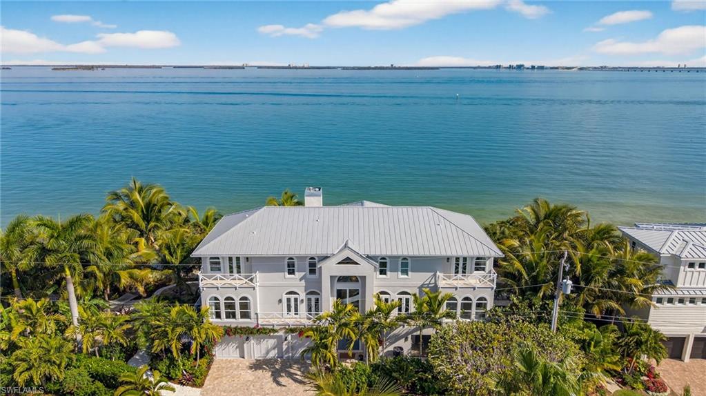 Sanibel Bayfront Masterpiece with expansive water views from every room. Located on a quiet street overlooking the Bay this home has every exquisite detail covered. Offering 4 bedrooms and 3.5 baths, one bedroom used as a den, all other bedrooms are ensuites including custom walk-in closets and private decks overlooking the Bay. Surrounded by lush native landscaping, the grounds around the home include a "Zen" garden with fountain/water feature, stone pathways, hammock and a firepit. There is a 3-car garage with epoxy floors with custom built-in cabinetry. The first floor offers flood protection barriers that surround the lower level of the home. The sparkling, saltwater pool is heated, fenced and has a spa that is under cover. There is a private 3-stop elevator that brings you to every gorgeous level of this custom home with engineered hardwood floors, impact windows and doors throughout and a reverse osmosis water system. The main living level has a wall of windows overlooking the Bay offering an open easy feeling of luxury from every angle. Volume ceilings, double sided fireplace, a welcoming place to gather your friends and family. The state-of-the-art kitchen has Wolf gas range, double wall ovens, built-in coffee maker, Subzero refrigerator and a Cove dishwasher. No expense was spared in this gourmet eat-in kitchen with breakfast bar, spacious dining area, fireplace and an Alfresco open dining porch. There is a large den/TV room that offers French doors to the dining porch. The large, private, primary suite sits on the third floor, has a built-in desk area beside a gas fireplace and a private sun deck. The primary bathroom has a soaking tub, glass shower, double vanities and bidet. Large custom walk-in closet with built-ins. Enjoy "Coastal Island" living at it's best. Home is being sold furnished with personal exceptions. Fantastic location, close to the beach, shopping, great restaurants and wonderful island amenities.