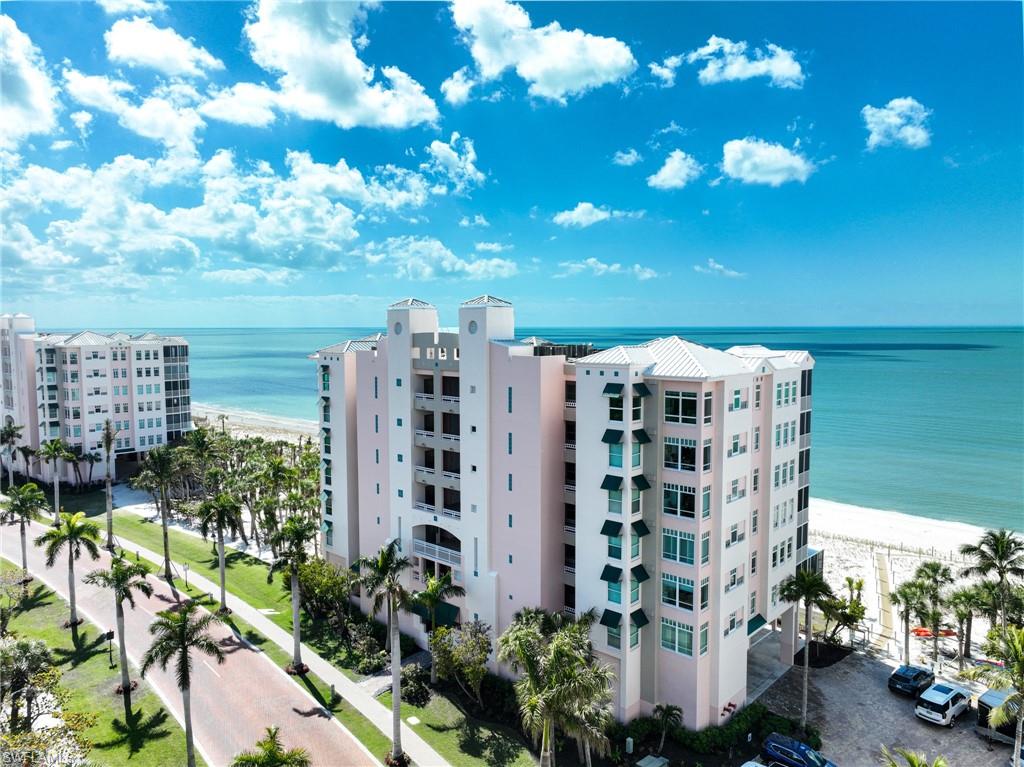 This Barefoot Beach end unit Penthouse offers the ultimate in luxury Florida beachfront lifestyle and is perhaps the finest condominium in the Barefoot Beach Club. This condo was taken to the bare concrete walls and totally reimagined to a timeless design where it is unrecognizable from the original floor plan. Enter via the custom lighted entry into immediate Gulf views via its open floor plan where the kitchen opens to the dining area & living room and they are all open to the screened lanai on the beach. The lanai offers outdoor dining, large seating area and a summer kitchen with grille all overlooking the turquoise water and white sand beach. There is a custom built sitting area offering hidden door access to the laundry room. The added half bath also is sleekly set into the wall with custom art camouflaging its location. The kitchen features a large island with cascading top, high end appliances, custom cabinetry, panoramic preserve & bayside views with amazing sunrises to the east, and wide Gulf views and sunsets to the west.  The living area highlights the penthouses already taller ceiling heights which have been maximized with low profile linear HVAC ducts & led spot lighting. There is both a large screen HDTV & in ceiling theater projection for movie night. There are custom ceiling and millwork details throughout including the outdoor lanai’s custom tongue & groove ceiling & wood design electric shutter boxes that bring the indoor quality outdoors. The master bedroom layout has been vastly improved with bed wall facing the Gulf. The master bath is stunning with his & her vanities, hidden storage, beautiful soaking tub, & walk in shower. The master bedroom closet is finished with custom cabinet quality. The two guest bedrooms with en-suite baths are finished to the same level as the master bedroom and bath. Other features include: fireplace, solid wood 8’ doors, 4” ceiling lights including the lanai ceiling, designer light fixtures & plumbing fixtures, wood plank tile flooring throughout, custom built-ins inc the open den area shelving, Impact windows & sliding doors. Best of all the Interior design furniture and furnishings are available for purchase for a quick seamless move in.  Barefoot Beach is Collier County’s premier gated Beach to Bay community featuring Royal Palm lined brick paver streets, 2 security guards 24 hours, and no public parking within the community. Barefoot Beach Club is a well managed & maintained family friendly Condominium Association. Gulf access boat dock leasing options are available. Option to join the Club at Barefoot Beach (located in the community) which offers casual & fine dining restaurants, pool & beachside food, drinks, chair service, indoor & outdoor bars, ice cream & coffee shop, tennis courts with pro & a full events calendar. (waitlist with usage during wait period). Barefoot Beach is centrally located to dining, entertainment, golfing, arenas & is close RSW Airport, the Promenade & Coconut Point.