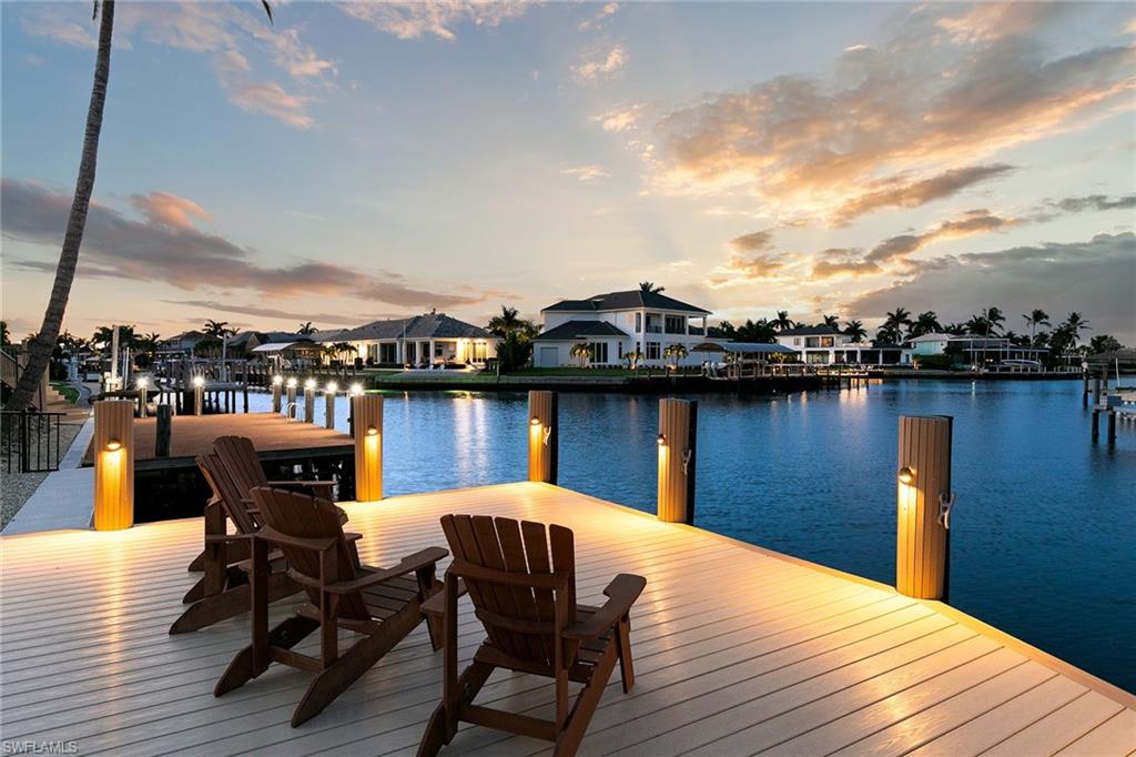 Experience the Best of Marco Island Waterfront Living. Perfectly positioned on 100 feet of intersecting canals with wide water views and direct boating access to the Gulf and Ten Thousand Islands, this extensively renovated waterfront residence offers the ideal blend of luxury, comfort, and effortless Southwest Florida lifestyle. Thoughtfully transformed between 2023 & 2025, every detail has been carefully curated to create a truly move-in-ready coastal retreat. Designed for both everyday living and entertainment, the home's open-concept floor plan encompasses 2,574 square feet with three spacious bedrooms, two full bathrooms, and a beautifully appointed powder room. Soaring vaulted ceilings, abundant natural light, and engineered hardwood flooring throughout the main living areas create a warm yet sophisticated atmosphere, while expansive water views provide a stunning backdrop from the home's primary living spaces. At the heart of the home is a spectacular chef's kitchen featuring custom plywood soft-close cabinetry, quartz countertops, dramatic oversized island with wraparound seating, designer glass tile accents, a shiplap ceiling, and premium appliances including an ILVE Majestic induction range, Sub-Zero Pro refrigerator, built-in microwave, and paneled dishwasher. Every element has been thoughtfully selected to combine exceptional functionality. The private primary suite serves as a peaceful waterfront sanctuary, complete with dual walk-in closets and a beautifully reimagined spa-inspired bathroom featuring dual vanities, freestanding soaking tub, and oversized walk-in shower. Guest accommodations provide exceptional comfort and privacy, while the elegant marble-appointed powder room adds another touch of luxury. Outdoor living is where this home truly shines. The resort-style pool was completely refinished in 2023 with new tile, pebble finish, marble decking, and heater, creating an inviting setting for year-round enjoyment. The custom outdoor kitchen features marble countertops, a Blaze stainless steel grill, beverage refrigerator, sink, and cedar tongue-and-groove ceiling, making it the perfect space for entertainment, while enjoying beautiful waterfront views. Boating enthusiasts will appreciate the new seawall and dock completed in 2025, featuring a 13,000-pound boat lift and private sundeck, providing immediate access to world-class fishing, shelling, waterfront dining, and endless days exploring the Gulf and Ten Thousand Islands. Modern conveniences are seamlessly integrated throughout the home, including enterprise-grade Ubiquiti Wi-Fi, whole-home Yamaha MusicCast audio with Klipsch in-ceiling speakers, Wi-Fi-enabled Panasonic smart thermostats, impact-resistant windows and doors, and roof replaced in 2019. Whether you're heading out for a sunset cruise, entertaining beside the pool, or simply relaxing with panoramic canal views, this exceptional residence captures everything that makes waterfront living on Marco Island so special.