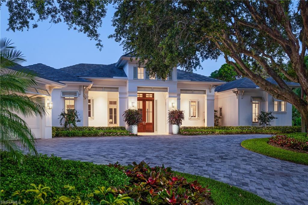 Panoramic lake views abound from this coastal chic, thoughtfully constructed, like new lakefront estate home. Sited on one of the most coveted lakefront lots in Pelican Bay, this homesite features 195' of lakefront. Enter through 12' mahogany and glass doors to a great room w/ vaulted 18' ceiling with beautiful natural wood trim detail. The open floor plan flows from the great room to the dining area and chef's kitchen, all overlooking southern exposure sliding glass doors showcasing a beautiful long lake view. Brilliant natural light, beautiful trim details, and hardwood floors throughout. Chef's kitchen features top-of-the-line appliances, an island, and plenty of storage. Luxurious master suite features a seating area and a stunning marble bathroom. Junior suite w/ a beautiful lake view, walk-in closet, and nicely appointed bath. A 3rd en suite guest bedroom, private office/4th bedroom, a wet bar complete the homes interior features. Outdoor living includes a 40' saline pool with integrated spa and sun shelf, outdoor kitchen, 3 car garage, whole house generator, and gorgeous lake views that wrap the backyard. Pelican Bay offers world-class private access to beachfront amenities.