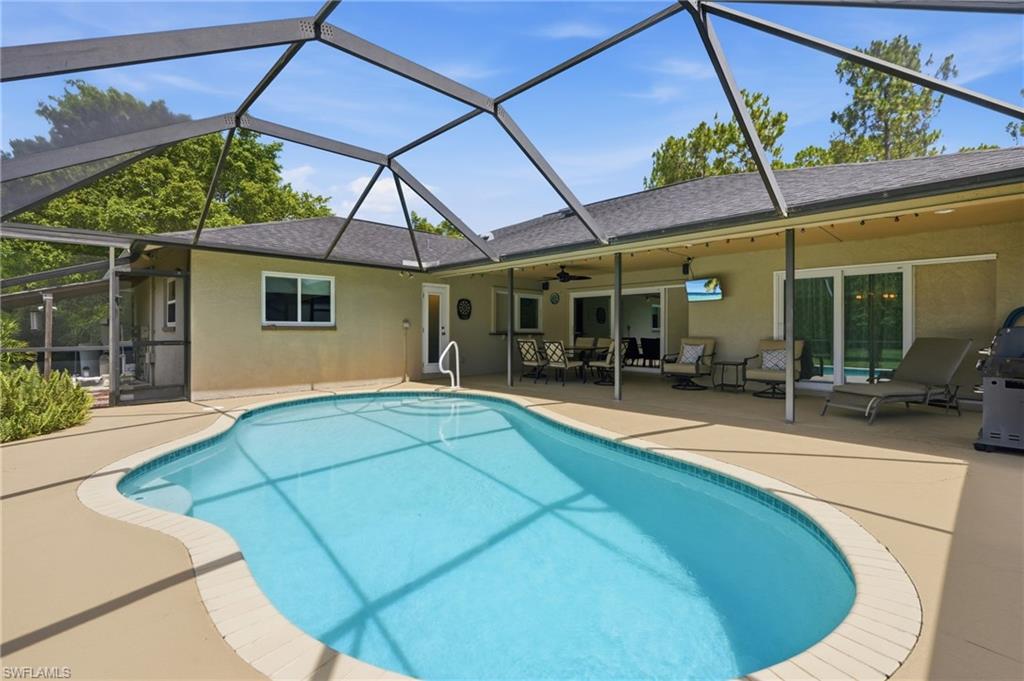 Set on 2.25 acres of high-and-dry land in Golden Gate Estates, this beautifully maintained pool home offers the space, privacy, and flexibility that have become increasingly difficult to find in Naples. With the majority of the property cleared and usable, there's ample room for outdoor recreation, hobbies, equipment, animals, or future additions—all while enjoying the peaceful setting of acreage living. Inside, nearly 2,000 square feet of living space is designed for both everyday comfort and entertaining. Spacious living and family rooms provide multiple gathering areas, while the island kitchen serves as the heart of the home. Impact-resistant windows throughout and a roof replaced in 2017 provide peace of mind, and thoughtful details such as walk-in closets in the guest bedrooms add to the home's functionality. Step outside to your own private retreat, where a screened pool and expansive covered lanai invite year-round enjoyment. A 14' x 14' gazebo creates the perfect setting for outdoor dining, relaxing, or hosting family and friends while overlooking the wide-open backyard. Adding exceptional versatility is a 400-square-foot metal building complete with 100-amp electrical service and water—ideal for a workshop, storage, recreational equipment, or your next project. One of the property's greatest advantages is its location. Just minutes from the Vanderbilt Beach Road extension, you'll enjoy convenient access throughout Naples while still experiencing the privacy and tranquility of estate living. Publix, schools, dining, and everyday necessities are all nearby, offering the perfect balance of seclusion and convenience. Combined with acreage, a private pool, and a versatile metal building, this property presents a rare opportunity to enjoy the space, flexibility, and freedom that define the Golden Gate Estates lifestyle.