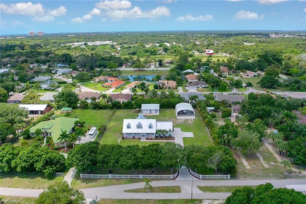 Amazing country setting with quick city access!  You will fall in love with this gated property that has a 2-story farm architectural flair, over 1.5 acres of land, detached 2-story garage/workshop, and a 40x50 detached carport with 18' ceiling. Perfect property to run a business from! All 4 guest rooms (one currently being used as a home office) are situated on the first floor and the spacious master suite w/ a huge master closet 14x18 & master bath is on the second floor. This custom built home features a massive great room w/ volume & cathedral ceiling, gas fireplace, gourmet designed kitchen, huge laundry room w/ tons of storage space & extras fridge, screened rear lanai, and open front porch. The detached 2-story garage has LOTS of storage space and could easily act as a workshop, plus the detached carport can hold heavy equipment easily. At the end of the road there is a community kayak/canoe launch area. VERY convenient location- only minutes from US 41, easy access to the airport & I-75, less than 2 miles from the Korshan State Historic Site, and only 20 minutes from the beautiful beaches of the Gulf of Mexico!