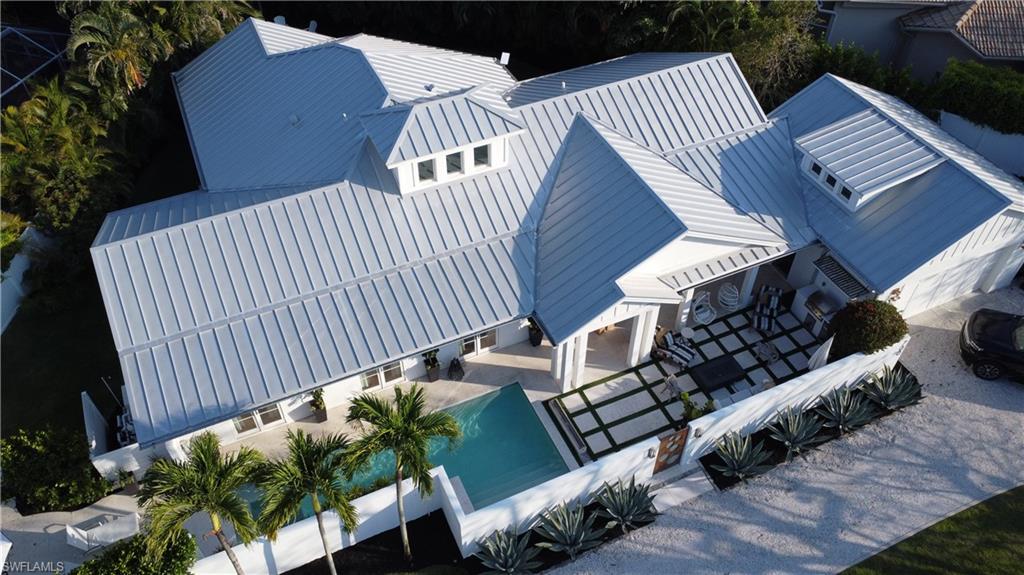 BEACH CLUB COTTAGE | Coastal Luxury in the Heart of Naples

Walk to Moorings Private Beach!

This stunning coastal contemporary courtyard home is the epitome of elegant Naples living—blending modern design with relaxed beachside comfort.

From the moment you enter, you're greeted with soaring ceilings and oversized windows that flood the home with natural light and blur the lines between indoor and outdoor living. Two private cabana-style bedrooms open directly onto a serene courtyard, framing the heated lap pool, spa, and calming water features—a true private retreat.

Inside, you'll find heart pine floors throughout the living areas, complemented by grey travertine in the bathrooms and laundry room. The gourmet kitchen is outfitted with top-of-the-line Wolf double ovens and a 6-burner gas range, paired with a 48" Subzero refrigerator/freezer—perfect for the serious home chef.

Enjoy cool evenings by the linear propane fireplace inside or gather around the fire poolside. With plans in place to triple the size of the pool and entertainment space, this home offers endless potential for luxury outdoor living. Live your Naples lifestyle worry free as this home is located in one of the few x-zones that has never flooded!

Additional highlights include:

Marvin hurricane-rated windows and doors

Standing seam metal roof

Concrete & stucco exterior

French drain system

Spray foam insulation for energy efficiency

Private beach access through The Moorings Beach Club

Walking distance to upscale shopping, dining, and the Gulf

 Full architectural plans available upon request.
 Whether you're entertaining guests or enjoying quiet mornings by the sea, Beach Club Cottage is a rare find that delivers the best of coastal elegance and modern comfort.