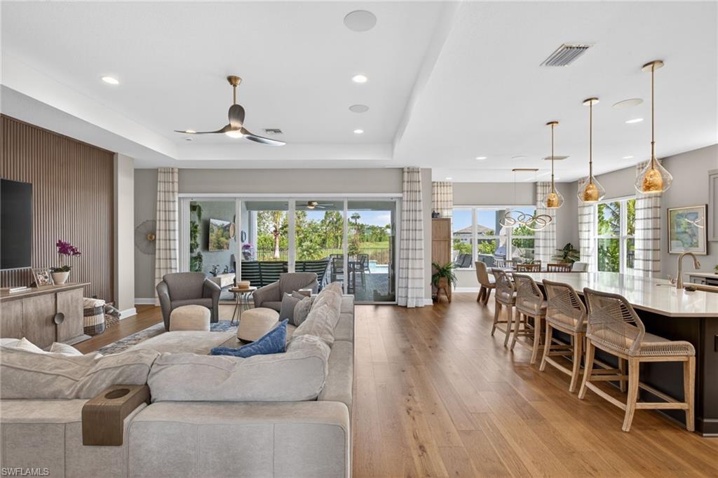 Luxury, style, and exceptional craftsmanship define this stunning Sunrise model, ideally positioned on a premium south-facing pond-view corner lot within one of the area's most sought-after 55+ communities. Designed for both elegant entertaining and everyday comfort, this meticulously upgraded residence showcases engineered hardwood flooring throughout the main living areas, plush carpeting in the bedrooms, custom woodwork, designer lighting, upgraded cabinetry, and sophisticated custom drapery that elevate every space. The gourmet kitchen is a chef's dream, featuring stainless steel appliances, a natural gas cooktop, exquisite quartz countertops, and a full quartz backsplash. The spacious primary suite serves as a private retreat, complete with professionally customized closet systems designed for both beauty and functionality. Step outside to your own resort-style oasis where indoor and outdoor living blend seamlessly. The expansive lanai is highlighted by a fully equipped outdoor kitchen, hurricane-rated screen enclosure, and breathtaking long-water views. Relax in the heated saltwater pool with sun shelf, unwind in the spa, or entertain guests while enjoying the tranquil pond setting and desirable southern exposure. 
Beyond your doorstep takes you to all that Valencia Trails offers —world-class amenities that enhance an active, social lifestyle. The impressive 43,000-square-foot clubhouse features a full-service restaurant and bar, a state-of-the-art fitness center, a full-service salon and spa, and multiple recreational spaces, including card rooms, an art studio, and a learning kitchen. For those who love outdoor activities, the community boasts a resort-style pool, a lap pool, a resistance pool, six tennis courts, eight pickleball courts, and scenic walking and biking trails. Even your four-legged companions will feel at home with two dedicated dog parks. This is more than just a home—it's an opportunity to embrace a luxurious, resort-style lifestyle in one of Naples' most exclusive communities. Every detail has been thoughtfully selected to create a home that is as luxurious as it is inviting. This exceptional property offers the perfect combination of premium upgrades, spectacular outdoor living, and the vibrant lifestyle of a premier active-adult community. A rare opportunity not to be missed.