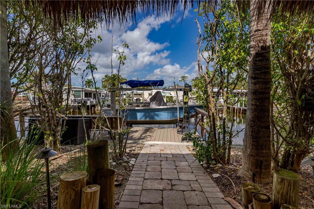 Lot 24 - Welcome to your private waterfront escape in Naples Motorcoach Resort, one of Southwest Florida’s most luxurious Class A motorcoach communities in beautiful Naples. This exceptional canal-front RV lot spanning an impressive lot and a half offers a rare opportunity to own an oversized slice of paradise with boating enjoyment right from your backyard.

A private dock with electric and water service makes boating effortless, while the 15,000-lb boat lift keeps your vessel ready for spontaneous adventures. From your dock, cruise through the breathtaking Ten Thousand Islands, head to Marco Island or downtown Naples to dock for lunch, or explore hidden barrier islands and secluded white-sand beaches accessible only by boat. Evenings are magical—imagine a peaceful sunset canal ride followed by relaxing back at your property with a glass of wine, cheese, and crackers as the sky turns brilliant shades of orange and pink.

Back on land, this property is designed for outdoor living and entertaining. The oversized tiki hut with custom tile flooring creates a beautiful covered gathering space surrounded by lush tropical landscaping that enhances privacy and the overall resort-style atmosphere. With the expanded lot-and-a-half footprint, there is abundant room to design and build your own casita, a highly desirable addition in the resort. A casita can provide additional indoor living space, a guest suite, full kitchen or bath, laundry, home office, hobby space, or a private retreat, adding both comfort and long-term value to your property.

This homesite offers the perfect canvas to design and build your dream motorcoach retreat, expand the paver areas, add custom hardscaping, incorporate a fire feature, outdoor kitchen, or a beautifully designed casita to complement the existing tropical setting.

Ownership also includes full access to the incredible amenities of Naples Motorcoach Resort, including:
• Three resort-style swimming pools
• Relaxing spas and saunas
• Elegant clubhouse and social spaces
• Pickleball courts
• Fitness center
• Dog park
• Community boat ramp with Gulf access
• Beautifully landscaped grounds and a vibrant social calendar

Whether you are boating the islands, enjoying sunset cruises, entertaining friends under your tiki, or designing the ultimate casita retreat, this oversized canal-front property offers the space, lifestyle, and luxury that make Naples Motorcoach Resort one of the most sought-after motorcoach communities in the country.

Create your dream waterfront motorcoach retreat and start living the Naples lifestyle today.
