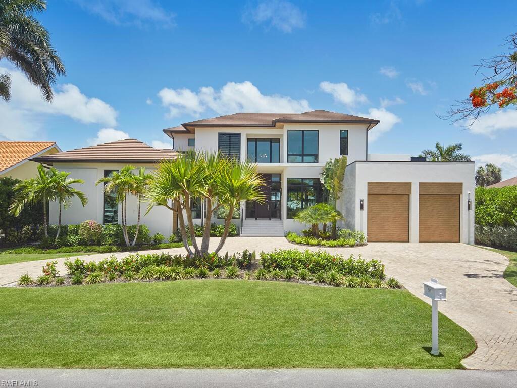 Newly completed in 2024, this exceptional Aqualane Shores waterfront residence delivers refined coastal architecture, deep-water boating access, and walkable proximity to Naples beaches and 3rd Street South.
A dramatic double-height foyer opens to light-filled living spaces where wide-plank French oak floors, custom millwork, and tailored finishes create a warm contemporary aesthetic. The chef’s kitchen is anchored by Sub-Zero, Wolf, and Miele appliances, natural gas cooking, bespoke cabinetry, and an adjacent butler’s pantry, flowing seamlessly into the great room and waterfront entertaining areas. A private club room with bar and designer lighting offers an inviting gathering space, while the main-level owner’s suite provides a serene retreat with spa-inspired bath and custom closets. Upstairs, a waterfront lounge, additional guest suites, and second laundry offer flexibility for extended family and guests. A private elevator services both levels. Outdoor living is designed for the Naples lifestyle with a resort-style pool and spa, summer kitchen, waterside fire feature, and generous covered seating overlooking the canal. Impact-rated windows and doors, smart-home integration, whole-home generator, and a spacious three-car garage with lift capability provide comfort and peace of mind. Set on a quiet, coveted street with direct boating access to Naples Bay, this newly built Aqualane Shores residence offers a rare combination of architectural quality, location, and modern waterfront living.