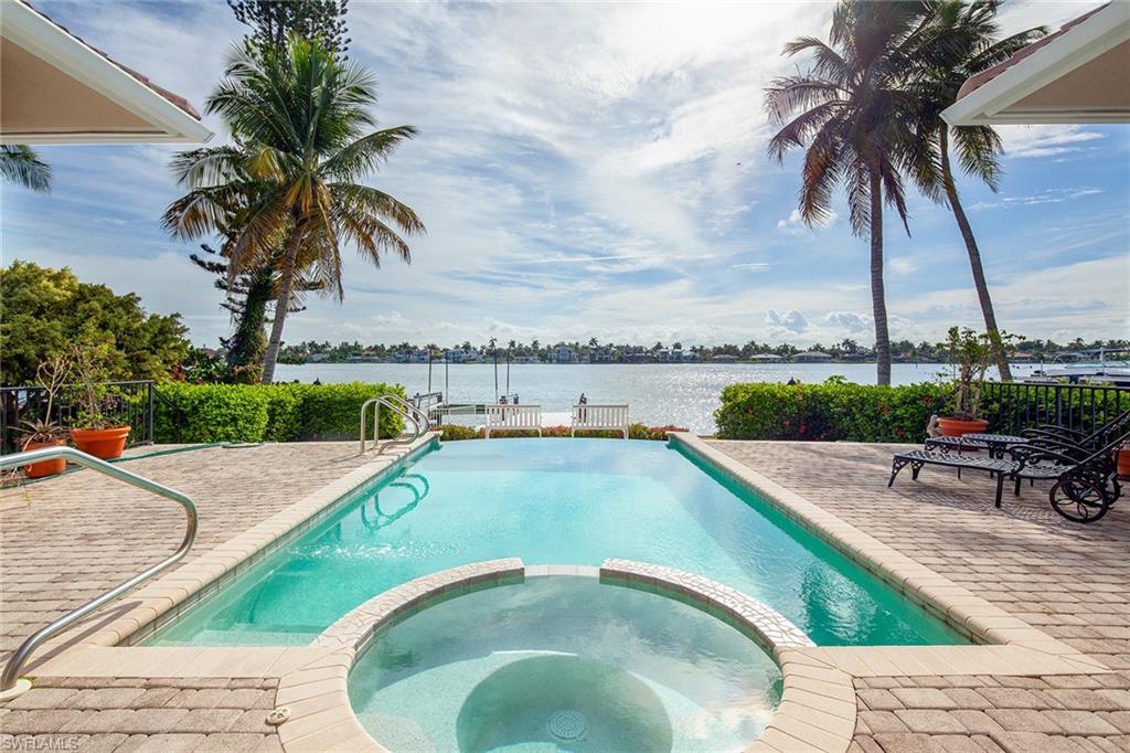 Location, Location, Location! Situated directly on Naples Bay this classic Aqualane Shores home offers the perfect location. It is comfortable walking distance along the tree-lined street to Naples beach and to the 3rd St downtown area. By boat, you are only minutes to the Gulf of Mexico from your backyard private, deep water, direct access dock. For car lovers, it provides ample garage space for 6 vehicles. This elegant home features panoramic views of Naples Bay from nearly every room. It is appointed with hardwood flooring in the main living areas, a private entrance full guest apartment as well as a separate entrance home office. The courtyard floor plan allows for the indoor living areas to flow seamlessly to the outdoor patios and pool area overlooking Naples Bay. Ideal for family living or entertaining. A unique opportunity, rarely available.