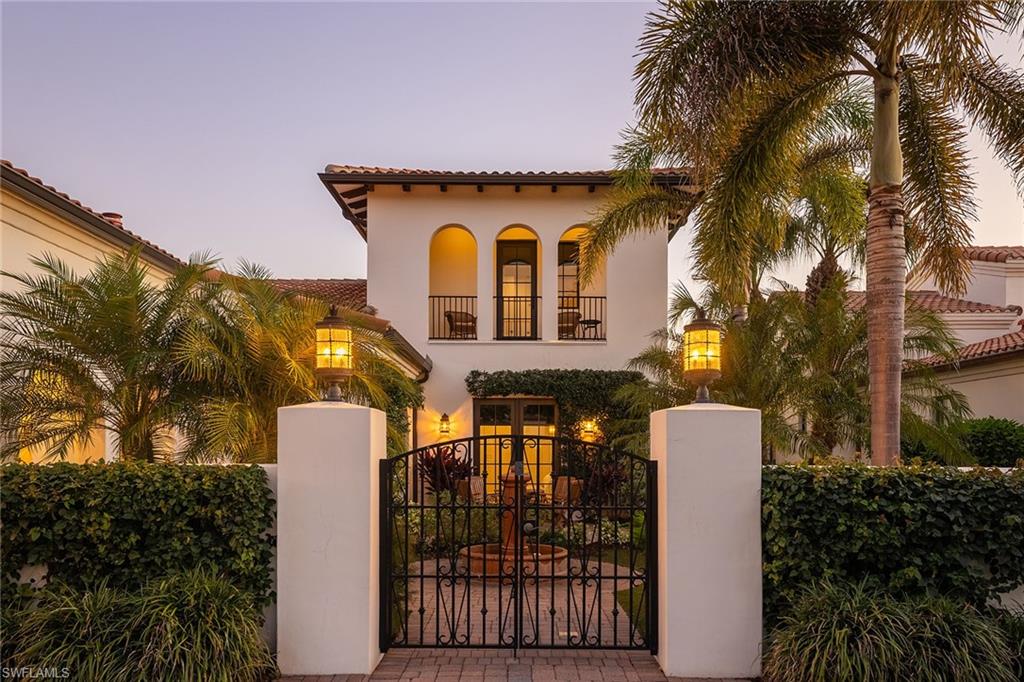 There’s a certain kind of home that does not shout, it simply welcomes. From the moment you enter the courtyard framed by flowering vines, a private entrance gate and a tranquil fountain, this Santa Barbara–inspired residence invites you to exhale. It lives like a private sanctuary, effortless, graceful and quietly luxurious. Inside, the design evokes California refinement. wide-plank Silver Oak Vintage Barrel wood floors anchor the interiors, meeting distressed pecan cabinetry. Curated original artwork and natural textures add depth and dimension, while Spanish tiles appear tastefully in the kitchen, fireplace surround, staircase risers and baths. Professionally styled by Olivewood Interiors, with a palette that is relaxed and elevated. Plumbing fixtures throughout are appointed in aged, oiled bronze offering a timeless appeal. The kitchen is equal parts elegant and functional, centered by a quartzite island while custom Omega cabinetry, top-tier appliances, gas cooking and a walk-in pantry with open shelving, generous counters and integrated drawers create a seamless culinary space. Beamed ceilings extend through the kitchen and into the great room, adding warmth and architectural continuity. The adjacent dining room is proportioned for intimate and formal gatherings. In the great room, the fireplace anchors the space with understated sophistication. Adjacent, the bar includes full-height wine storage behind an iron gate and a built-in wine refrigerator, ideal for entertaining or everyday ritual. Take advantage of the office area featuring oversized windows and seamless connectivity to outdoor living areas. With direct pool access, the primary suite offers tranquil lake views and spa-style finishes, creating a restful and refined retreat. Three guest suites offer ample comfort, each with thoughtful separation and en-suite accommodations. Upstairs, the versatile retreat opens to a balcony with long lake views, an ideal setting for use as a lounge or guest space. Blurring the line between indoor comfort and outdoor serenity, the saltwater pool is enveloped by the water vistas. Travertine tile from Italy was carefully selected for the lanai and pool deck, offering texture and elegance underfoot. The covered outdoor living space features a tongue-and-groove ceiling and a fully equipped summer kitchen and retractable screens for year-round comfort. The relaxing pool area is enhanced by the sounds of a Spanish fountain and the ambient glow of a gas firepit, creating a tranquil setting for unhurried afternoons and sunset gatherings. Impact-rated windows and doors, remote-controlled screens and a whole-home Sonos system provide modern convenience as well as water filtration and a power generator. In the award-winning community of Mediterra, with 36 holes of Tom Fazio golf, Har-Tru tennis, pickleball, bocce and a private beach club, along with a new Sports & Lifestyle Center coming soon to enhance wellness and connection!