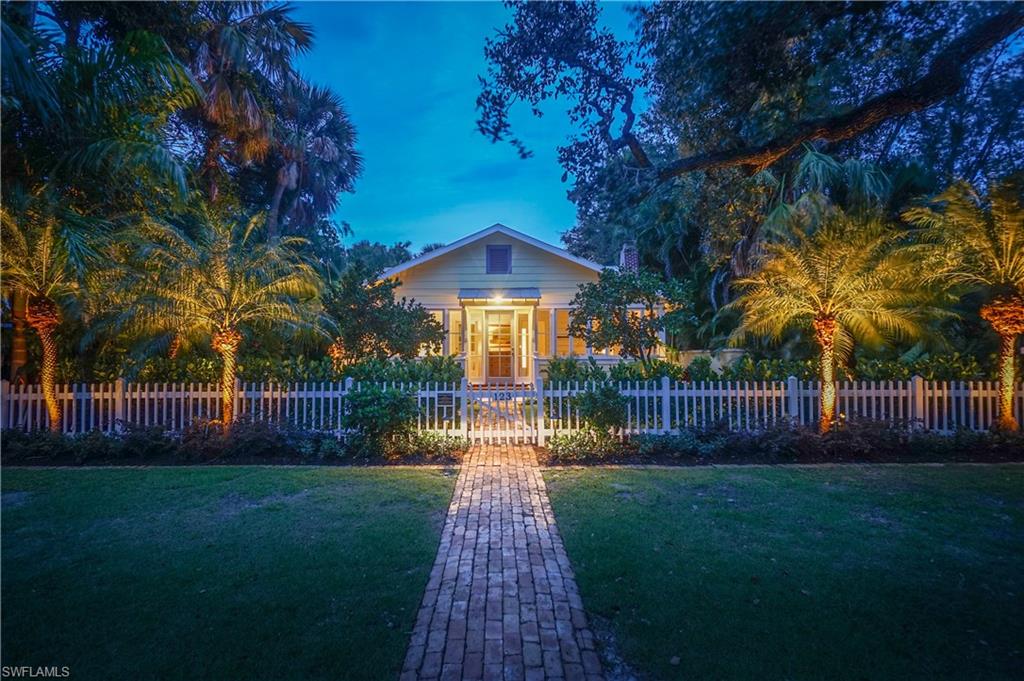 The historic "Periwinkle Cottage," c. 1935 as featured in “Dream Houses: Historic Beach Homes and Cottages of Naples,” is a prominent landmark property located in the heart of Olde Naples. Situated in the heart of Old Naples on one of Old Naples’ most charming streets and just steps to the renowned sugar sand beaches of the Gulf of Mexico, this home is perfect for entertaining. Custom landscaping and lighting design, Old Chicago Brick, Zoysia grass, mature trees, a picket fence, and outdoor living space that features a pool, large lanai, dining, and grill area.  The recently renovated cottage catches the spirit of early Naples without sacrificing today's modern amenities. The rare refinished hardwood floors, tongue & groove ceilings, and custom millwork blend harmoniously with new custom cabinetry including top of the line appliances. The back portion of this unique cottage is a charming attached one bedroom guest house with high beamed ceiling, fireplace, wainscoting, and kitchen. Above the garage with alley access is an additional living area currently used as a large guest suite. This cottage is a perfect, sublime escape sure to enchant your family and friends.