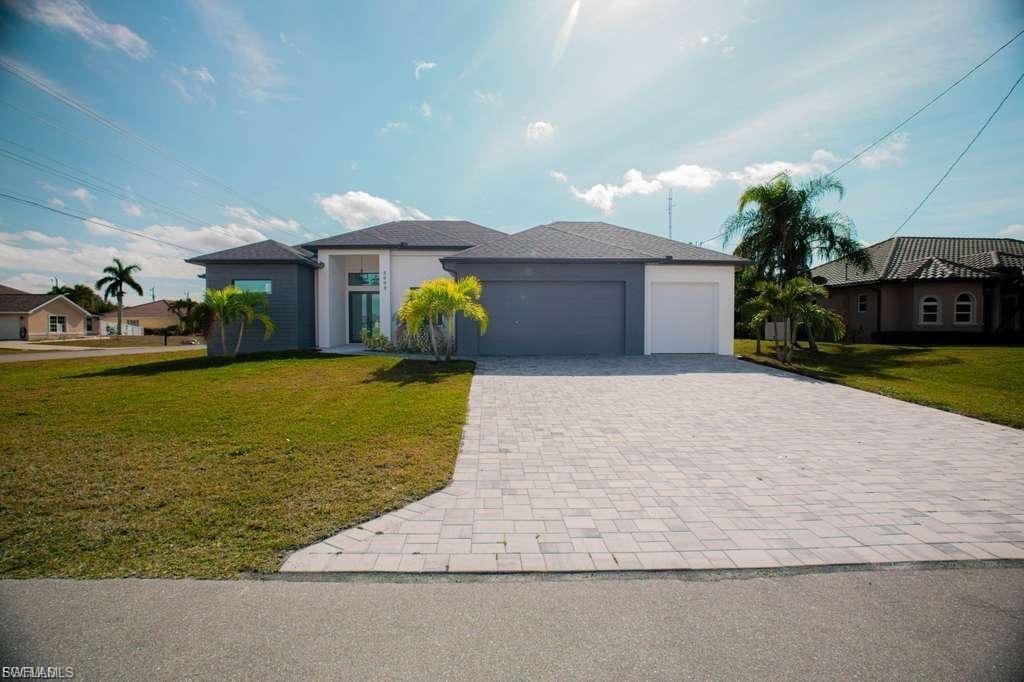 Stunning new construction home on a corner lot with a private pool, located in the highly desirable Southwest Cape Coral area. This 4-bedroom, 3-bath residence offers a modern design with luxury finishes, including 24”x48” porcelain tile throughout, soaring 18-foot ceilings with coffered ceiling details in the living room and master suite, and a sleek 65” electric fireplace as a stylish focal point. The kitchen and bathrooms feature high-gloss wood cabinetry and 2” Calacatta White quartz countertops. Additional highlights include an insulated garage door and a smart layout perfect for enjoying the Florida lifestyle.